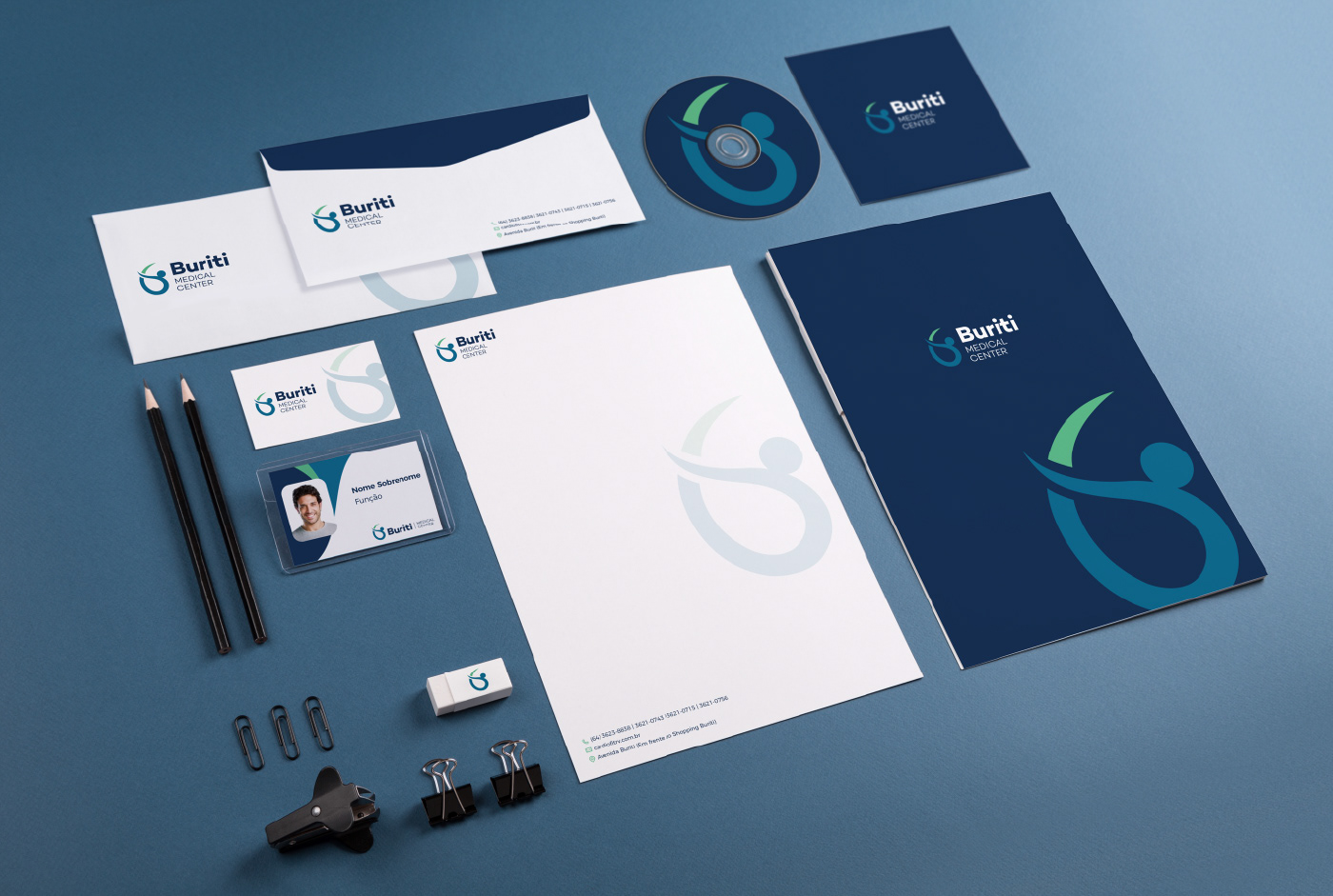 Materiais de papelaria do Buriti - Medical Center, com logo e informações de contato, nas cores azul, verde e branco.