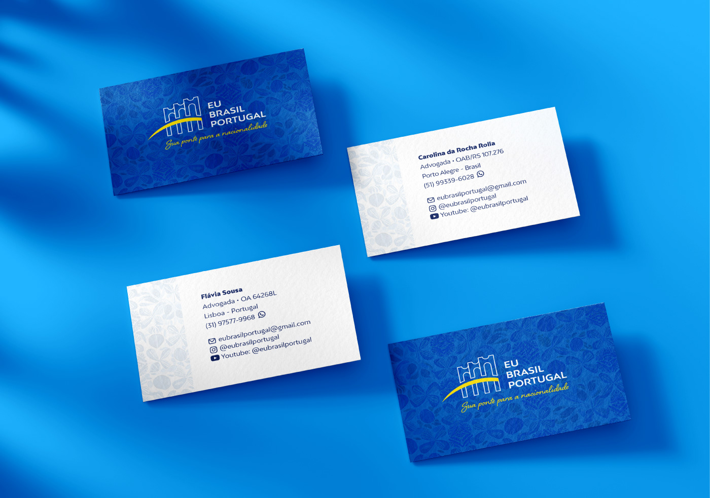 Fundo azul e sobre ele 4 cartões de visita da "Eu Brasil Portugal" com o logo, textura padrão e informações de contato.