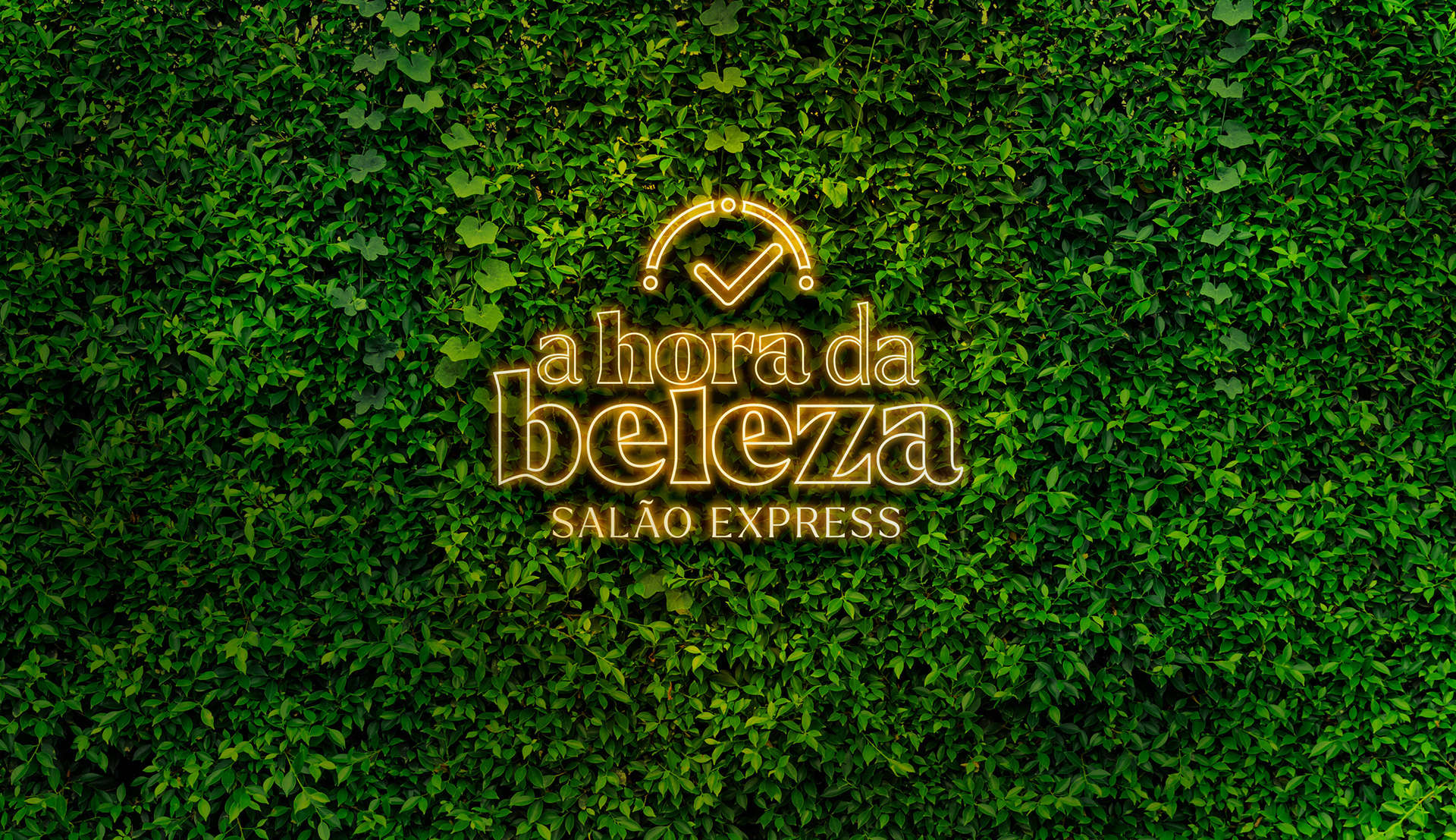 Logotipo luminoso de 'A Hora da Beleza Salão Express' em neon, destacado em uma parede de folhas verdes, simbolizando vitalidade e renovação.