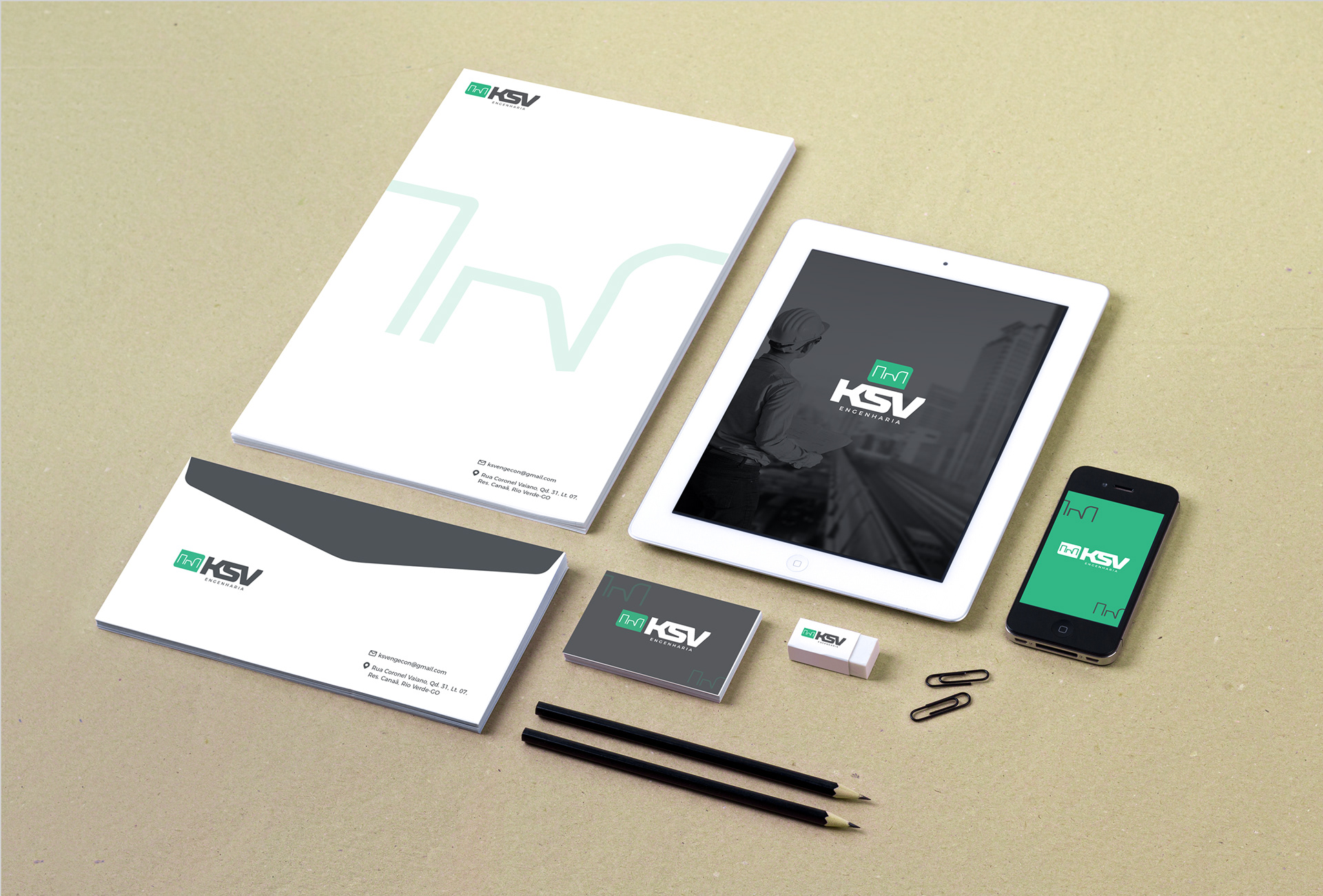 Papelaria personalizada da KSV engenharia, com logo e informações de contato, tablet e celular com banner digital.