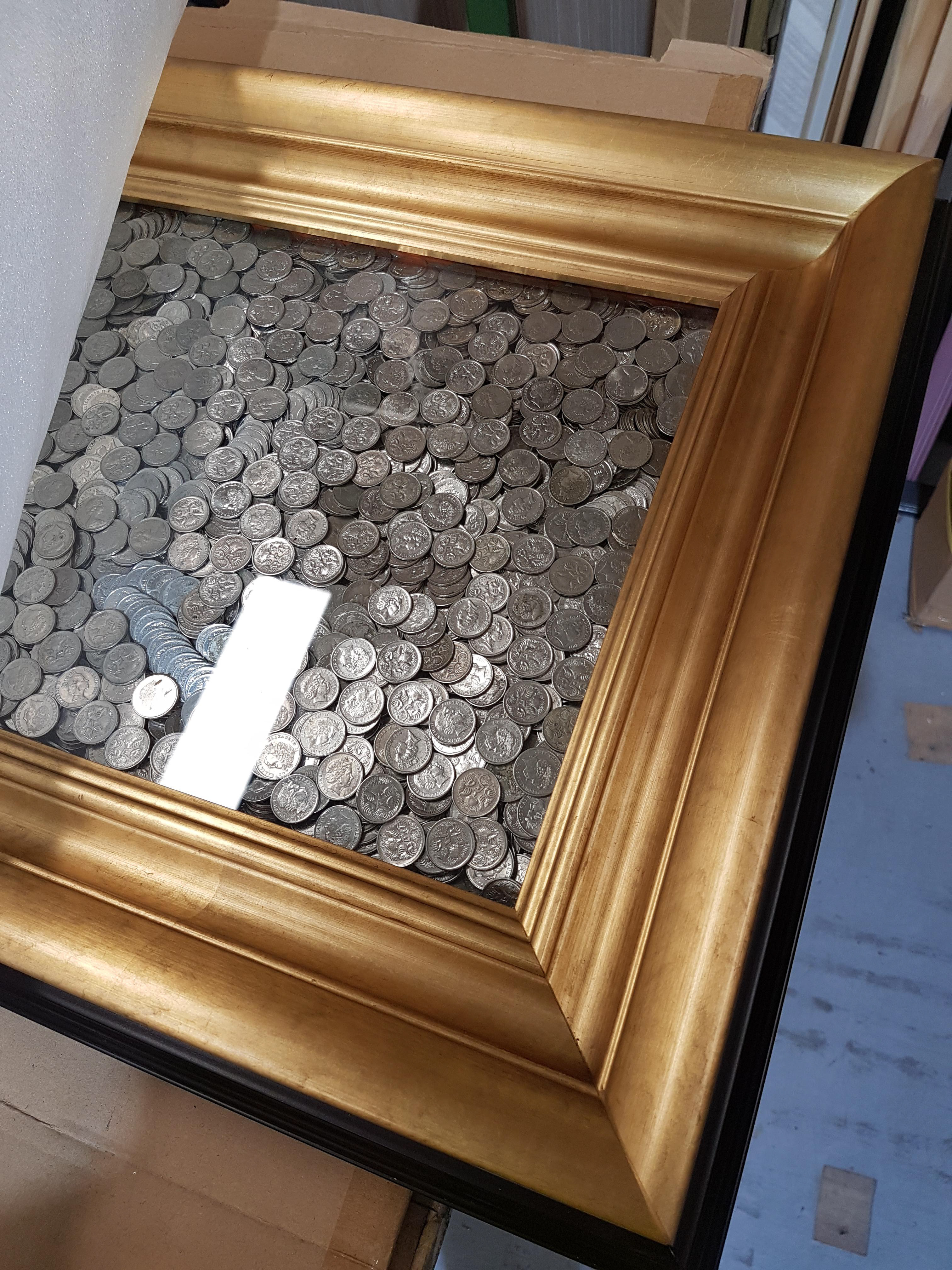 Close up of Australian 5 cent pieces in a giant gold-framed picture frame totalling $700.