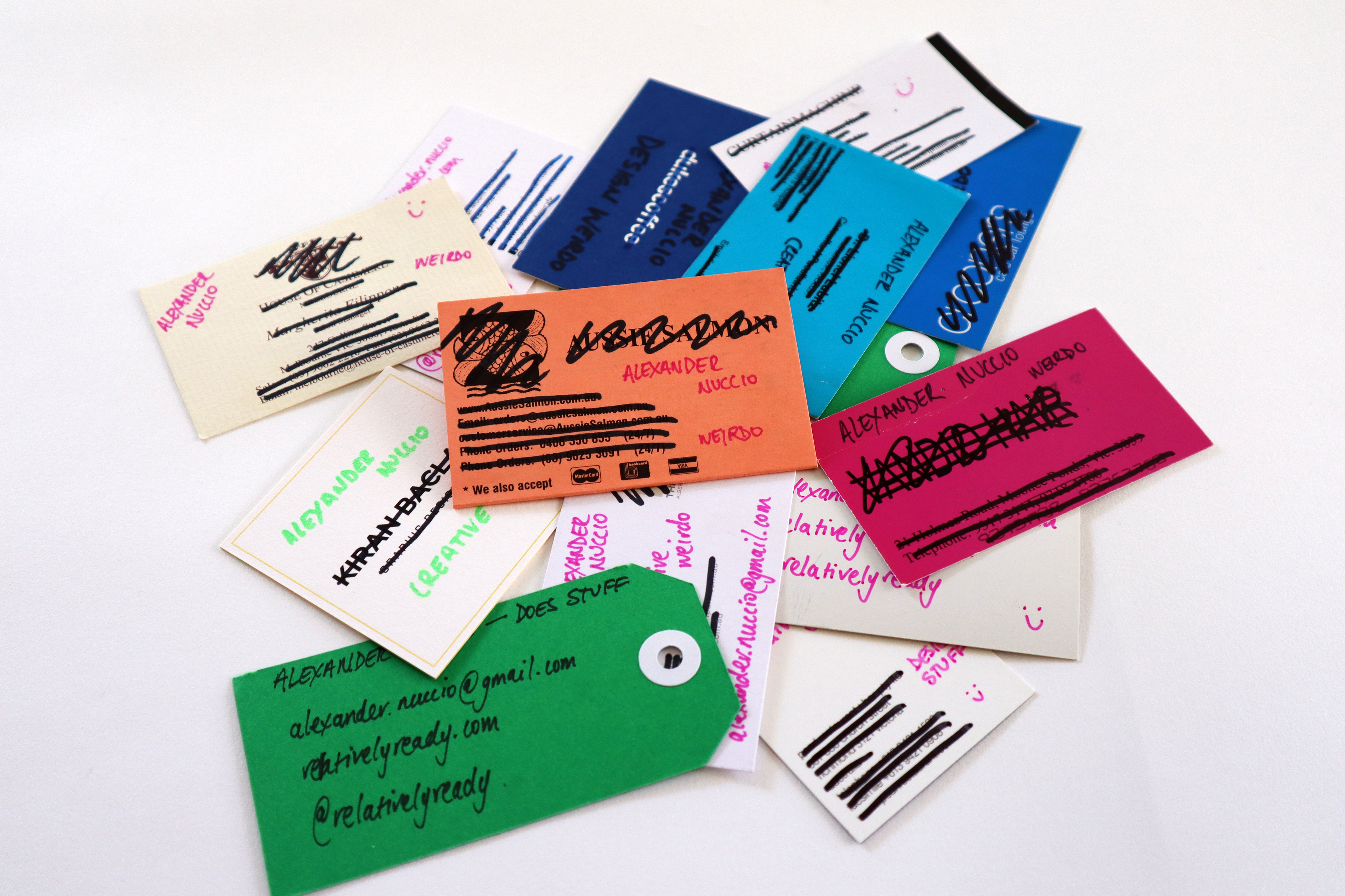 A stack of business cards with the original business details crossed out and relatively ready details hand-written in.