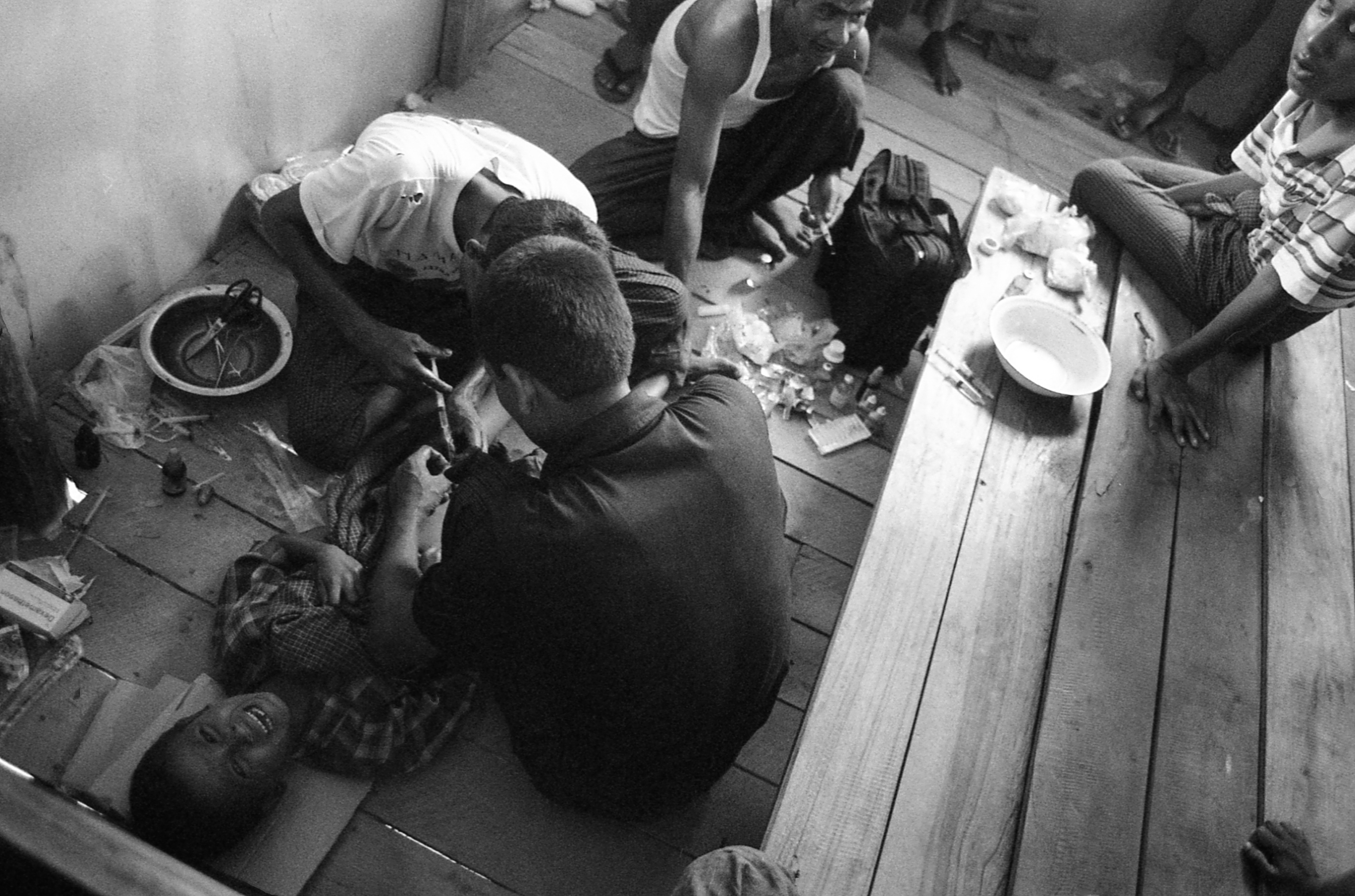 Thakkay Pyin IDP Camp, Myanmar. In an abandoned school, a boy cries verses from the Quran as he is circumcised.