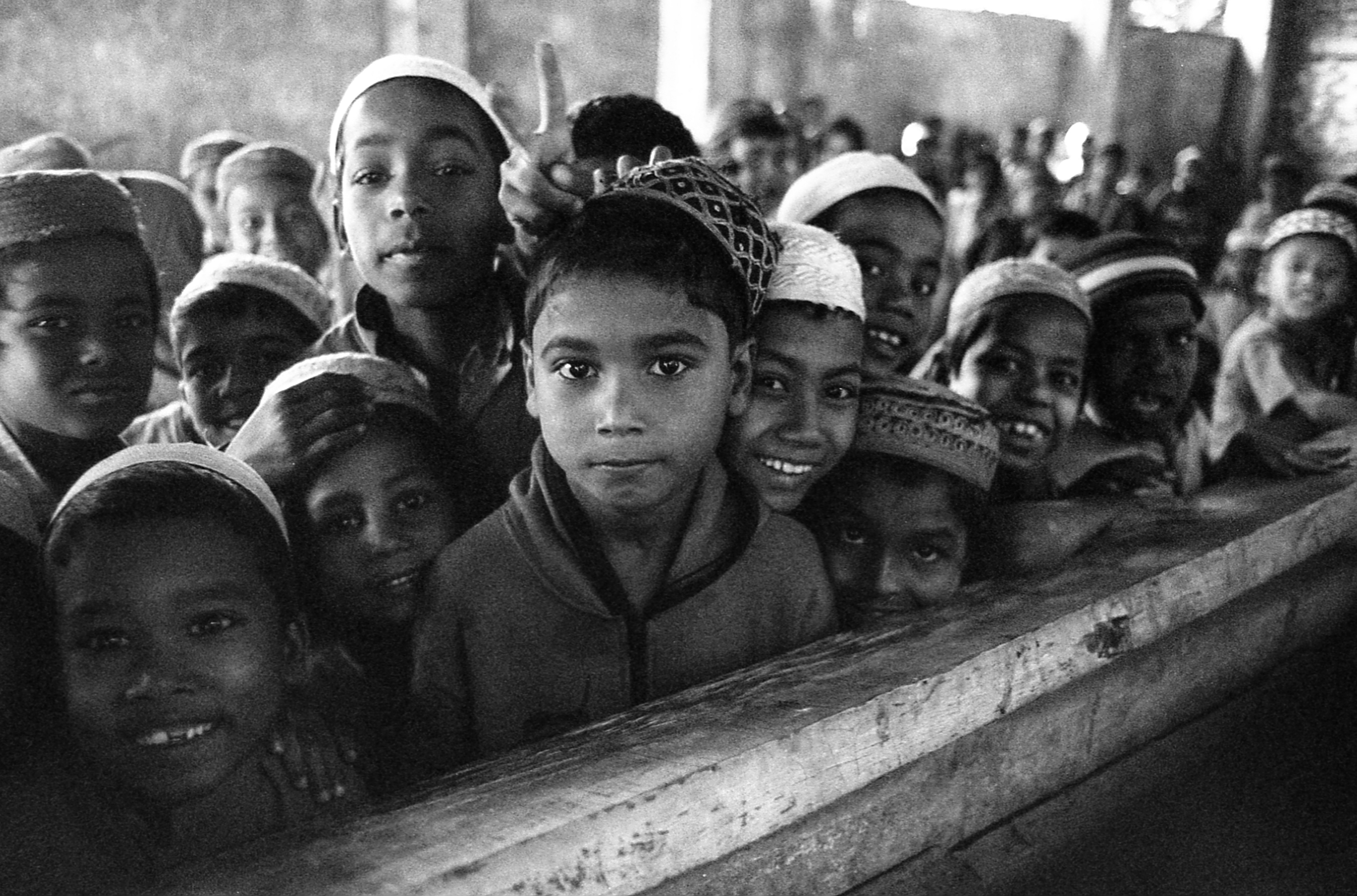 Shamlapur, Bangladesh. Primary students poke their heads out of the classroom during a morning break.