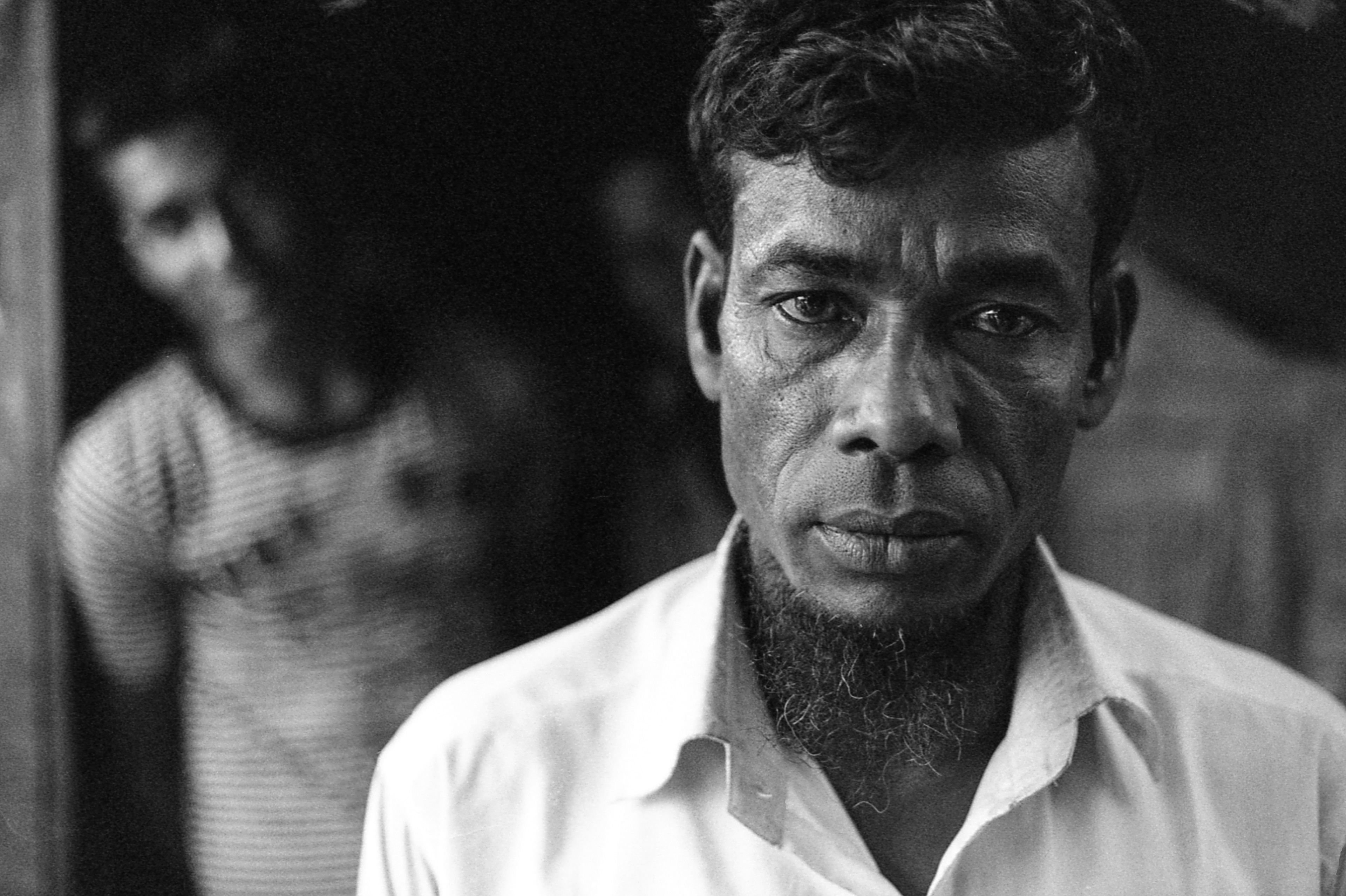 Leda Camp, Teknaf, Bangladesh. Nurul Islam was the chairman of his village in Myanmar for 14 years before he was tortured and expelled from Rakhine State for rebuilding a mosque after the rainy season. For 6 days, he was bound by his hands and feet and beaten, until he managed to escape to Bangladesh. He is pictured here with his son, Shahid, who made an unsuccessful attempt to flee by boat to Malaysia and now works as a photographer on the beach in Cox's Bazar.