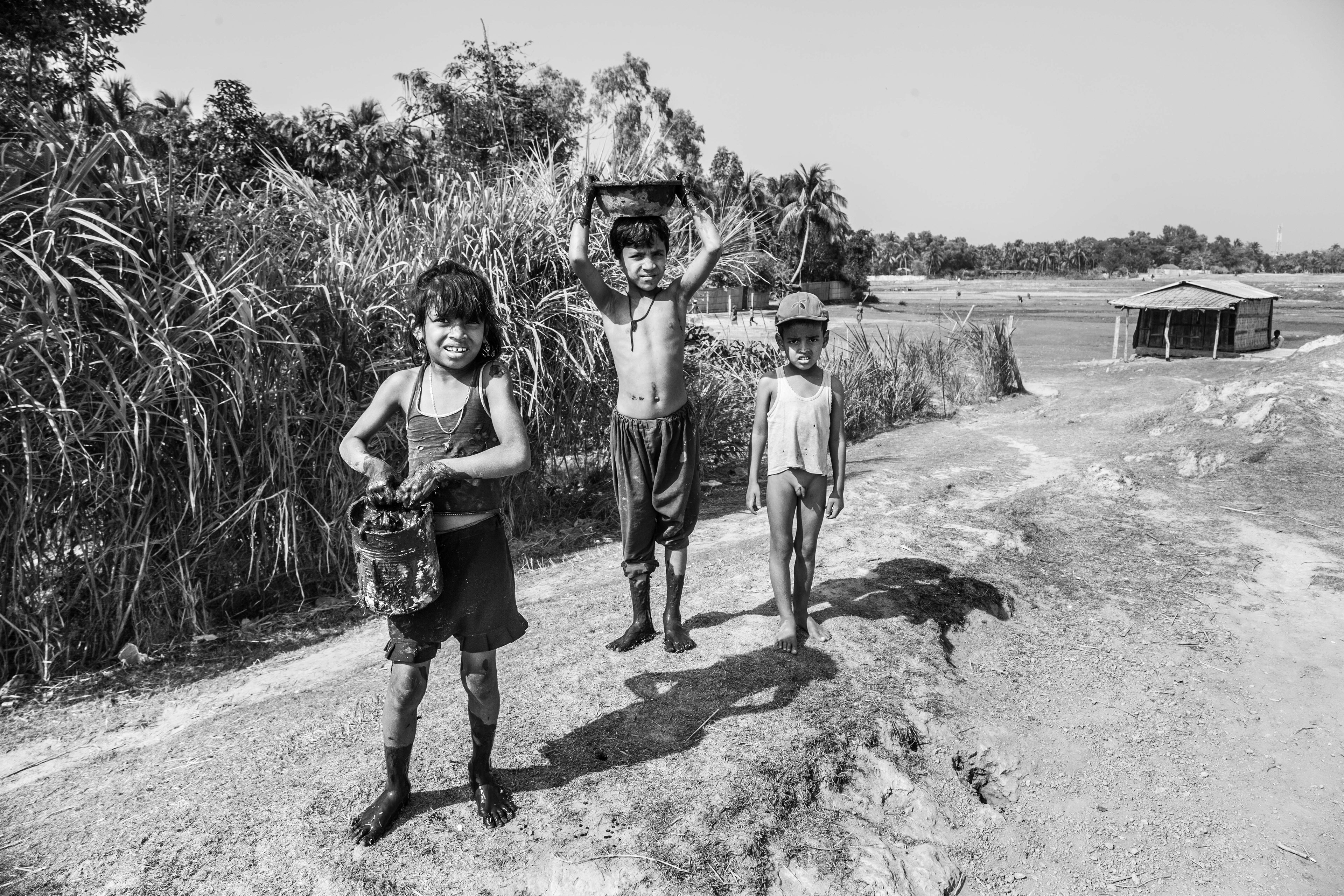"To Make a Home." Shaforidip, Bangladesh. Jan 2016. At the southernmost tip of Bangladesh, Sharofidip is a shelter for many Rohingya fleeing the violence and persecution in Myanmar. These children are collecting thick mud to help build their family’s temporary home here.