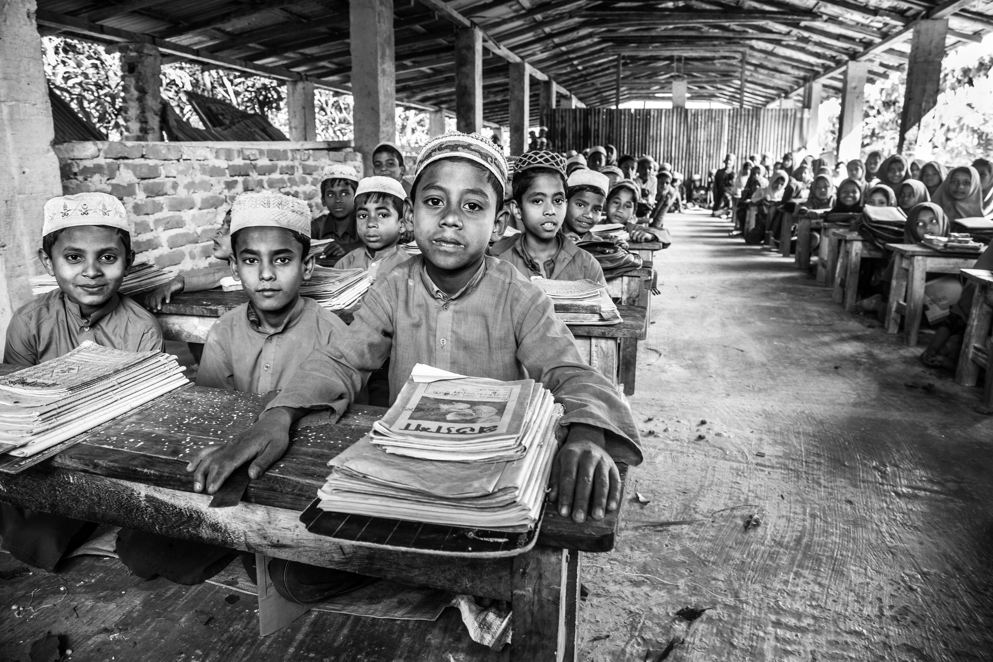 "Boys and Girls." Shamlapur, Bangladesh. Jan 2016. Boys and girls are split down the middle in this impromptu classroom, and receive more advanced lessons from those offered downstairs. In all, there are about 400-500 students here, a mix of Rohingya and Bengali.