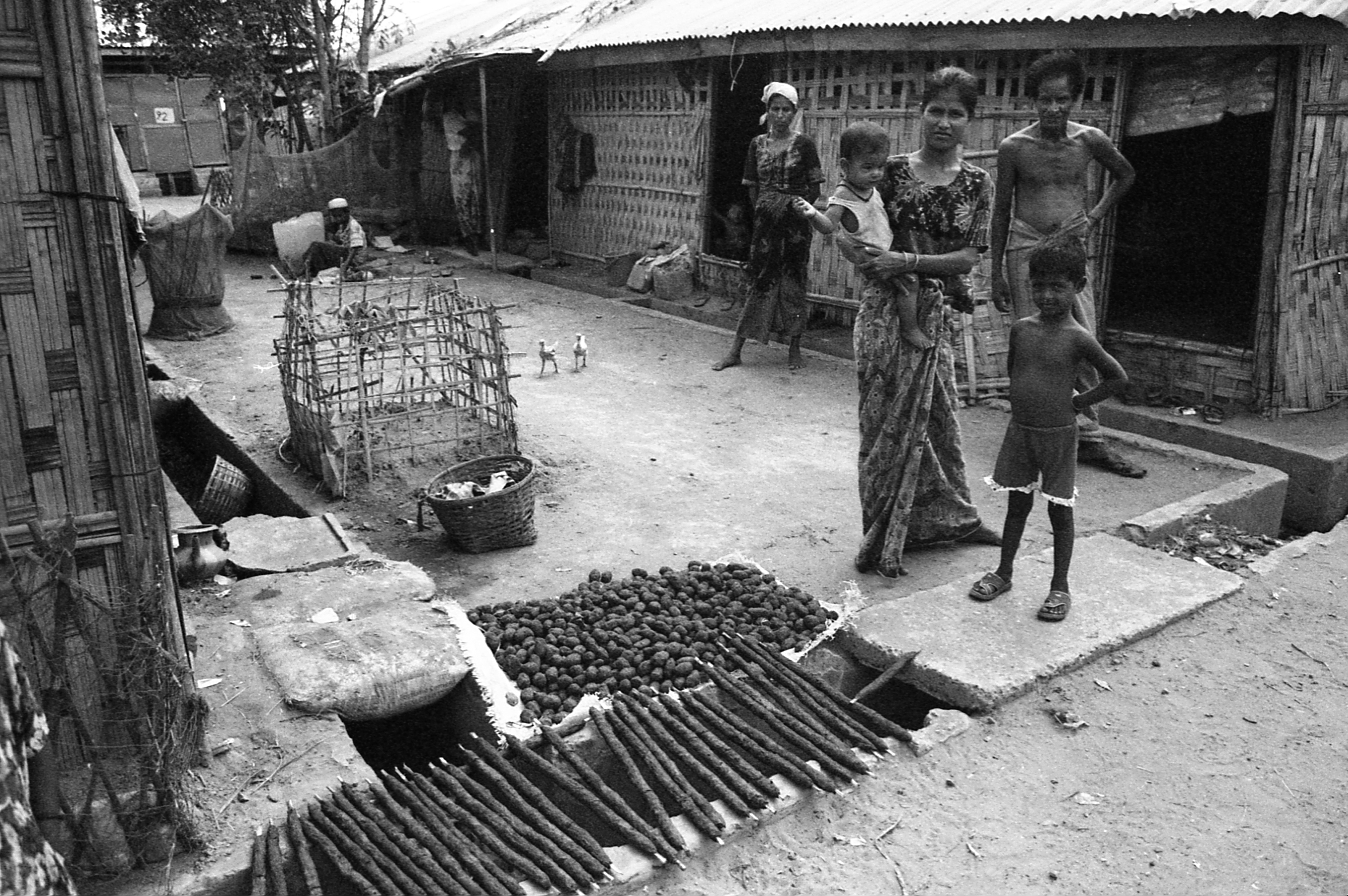 Baw Du Ba IDP Camp, Myanmar. A family dries cattle dung to be used for charcoal.