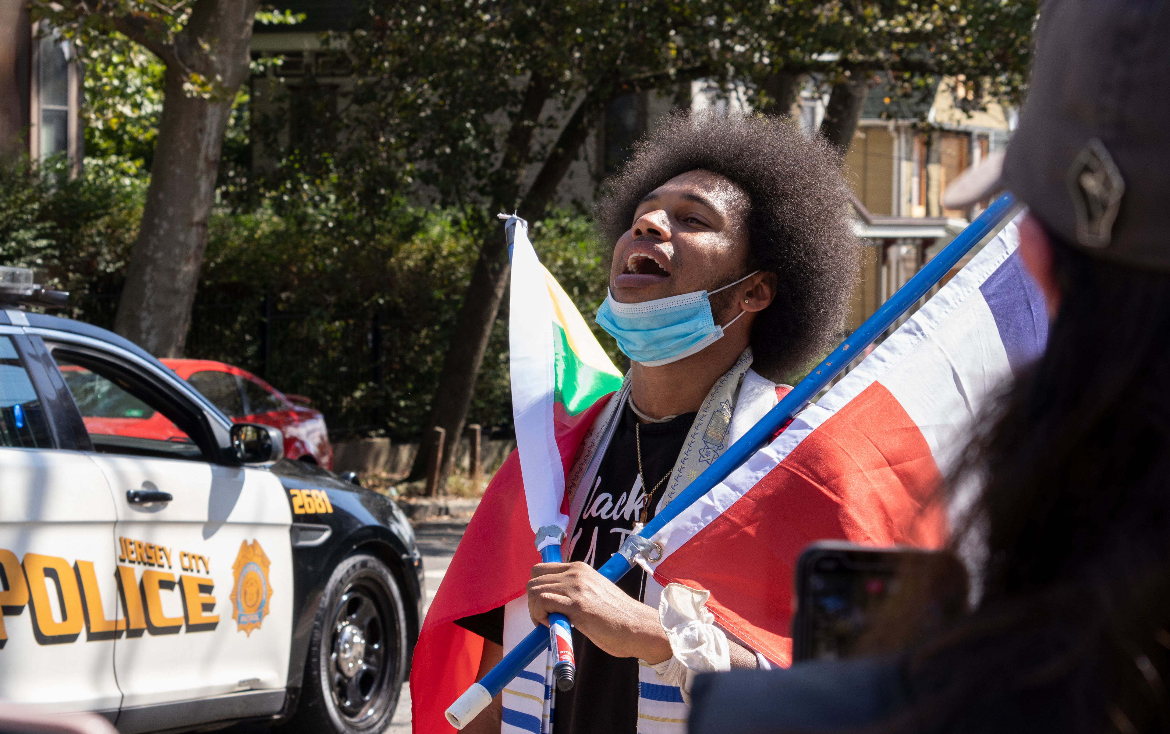 West Orange native Rostafa leads the march along John F. Kennedy Boulevard holding two flags. The march starts from Audobon Park and ends at Berry Lane Park where the first Kemet Festival is being held which includes speakers, music, and vendors. (Photo/Sunah Choudhry)