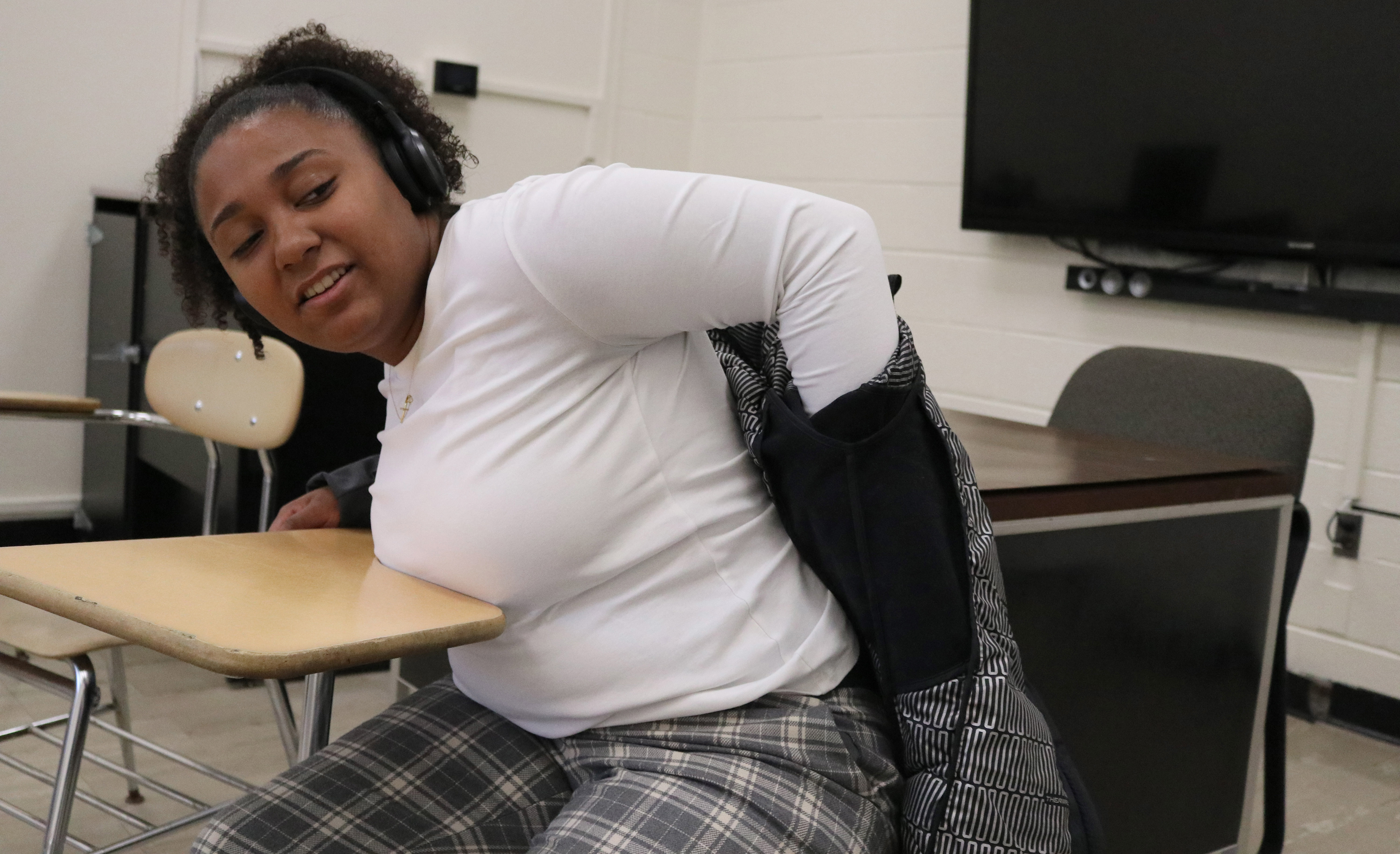 MONTCLAIR, NJ 11/11/2019 THE STRUGGLE OF DESKS: Trinity Corney struggles to get her jacket off after making the trek to Calcia Hall at Montclair State University. She complains about the desks and how hard they are to get into with her backpack and jacket on. -Photo by Sunah E. Choudhry