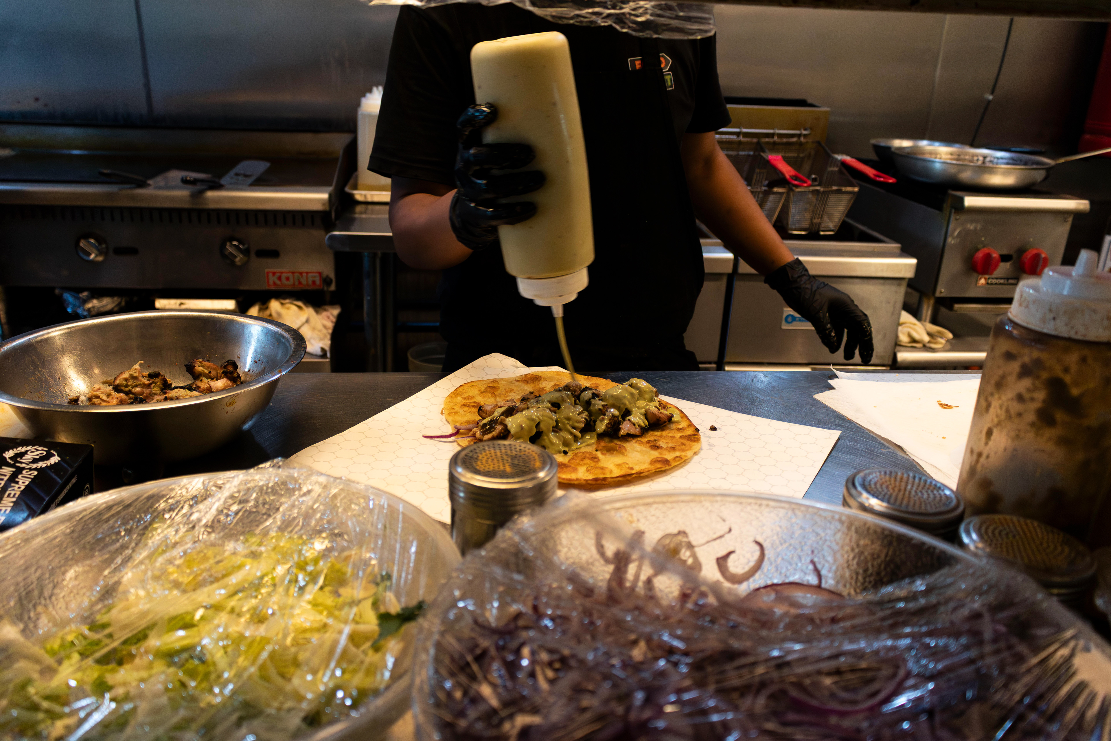 A cook prepares a chicken tikka paratha roll at Food Street in Secaucus. Photo by Sunah Choudhry.