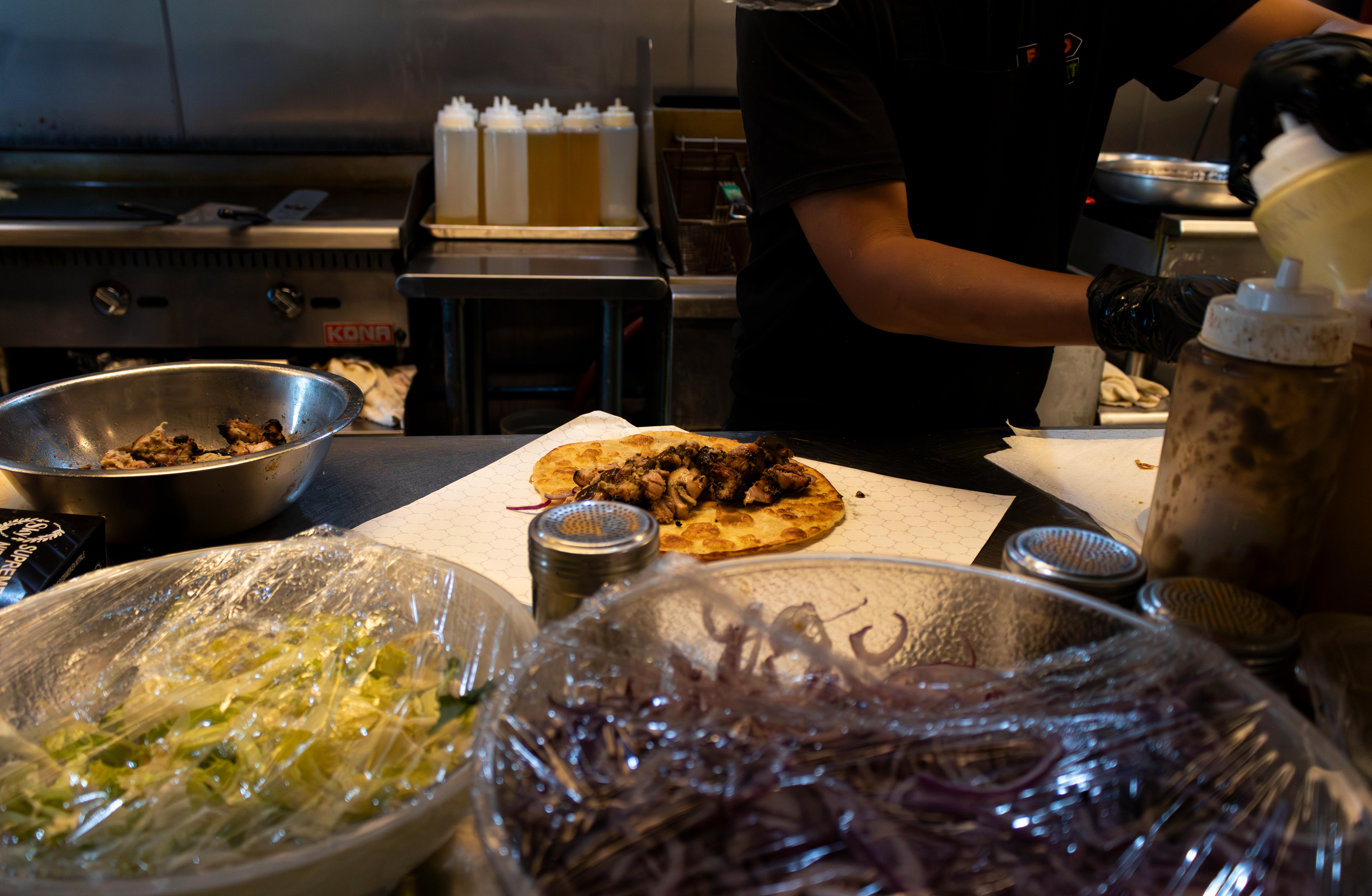 A cook prepares a chicken tikka paratha roll at Food Street in Secaucus. Photo by Sunah Choudhry.