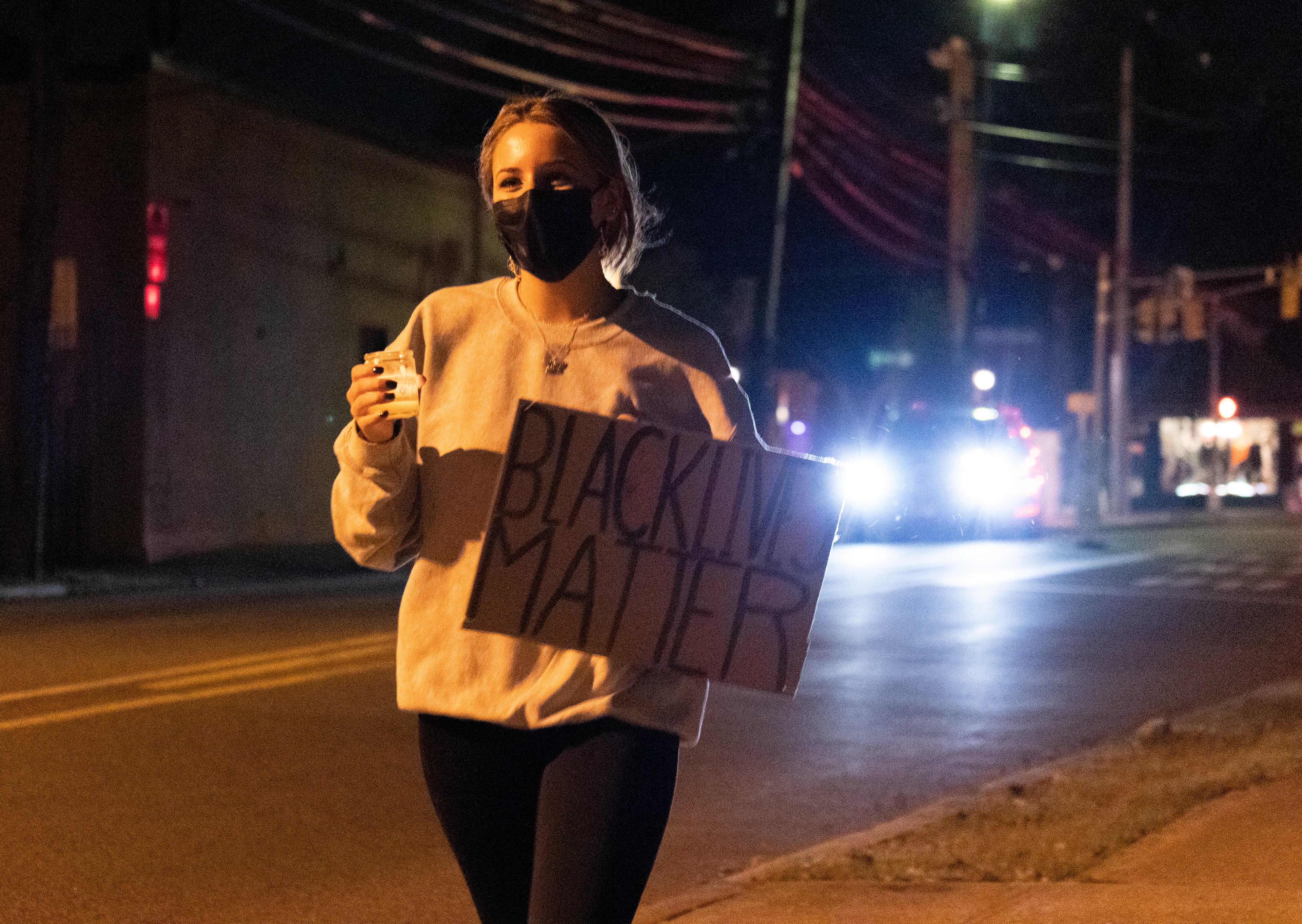 A student from Ramsey High School holds a candle in front of Ramsey town hall. (Photo/Sunah Choudhry)