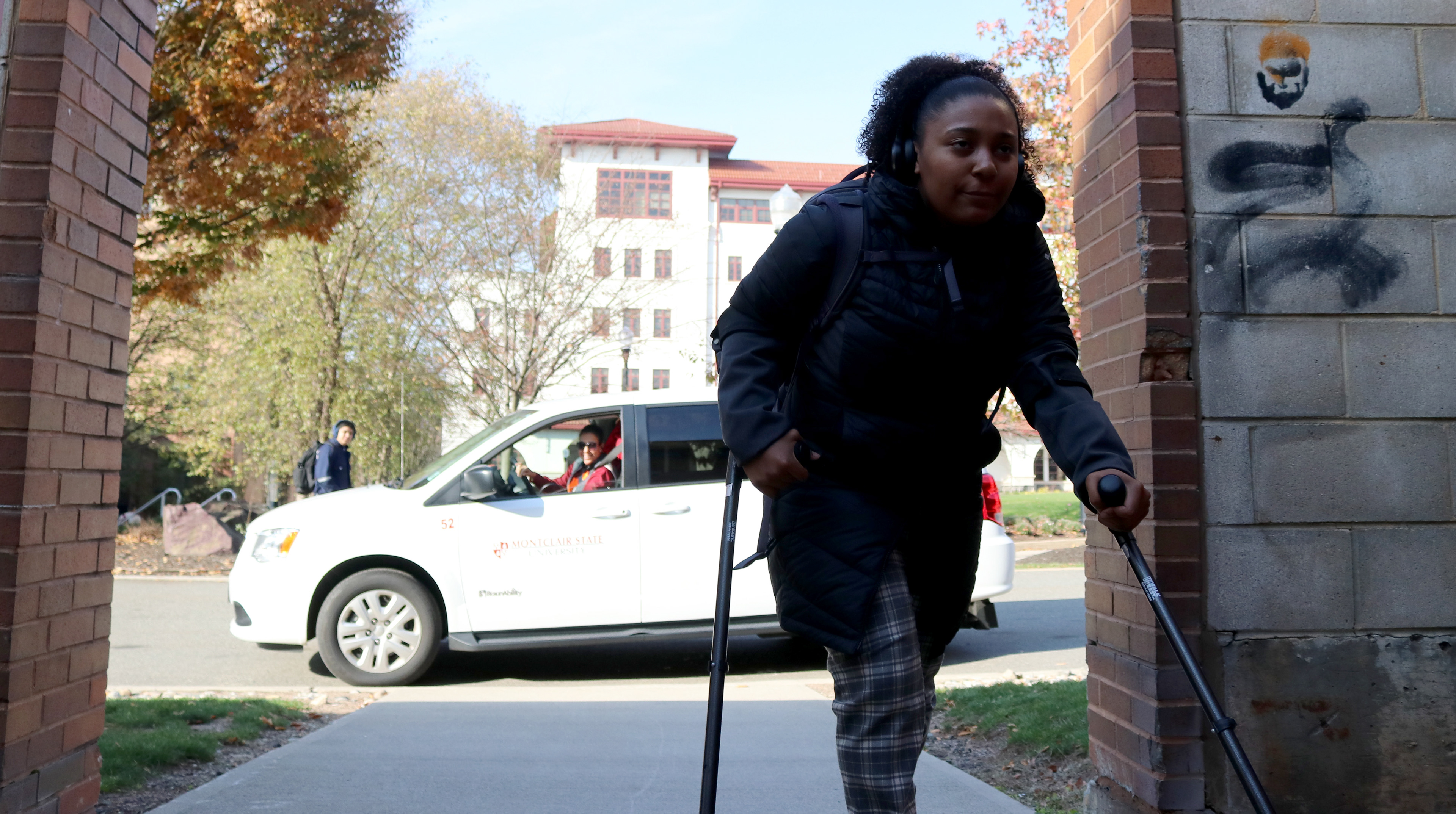 MONTCLAIR, NJ 11/11/2019 ALMOST THERE: Trinity Corney reaches her destination at Calcia Hall but has another goal on her mind. She sees Amy Albin struggling to figure out where she should be walking. Behind Trinity is the disability vehicle and is there to pick up Amy.  -Photo by Sunah E. Choudhry