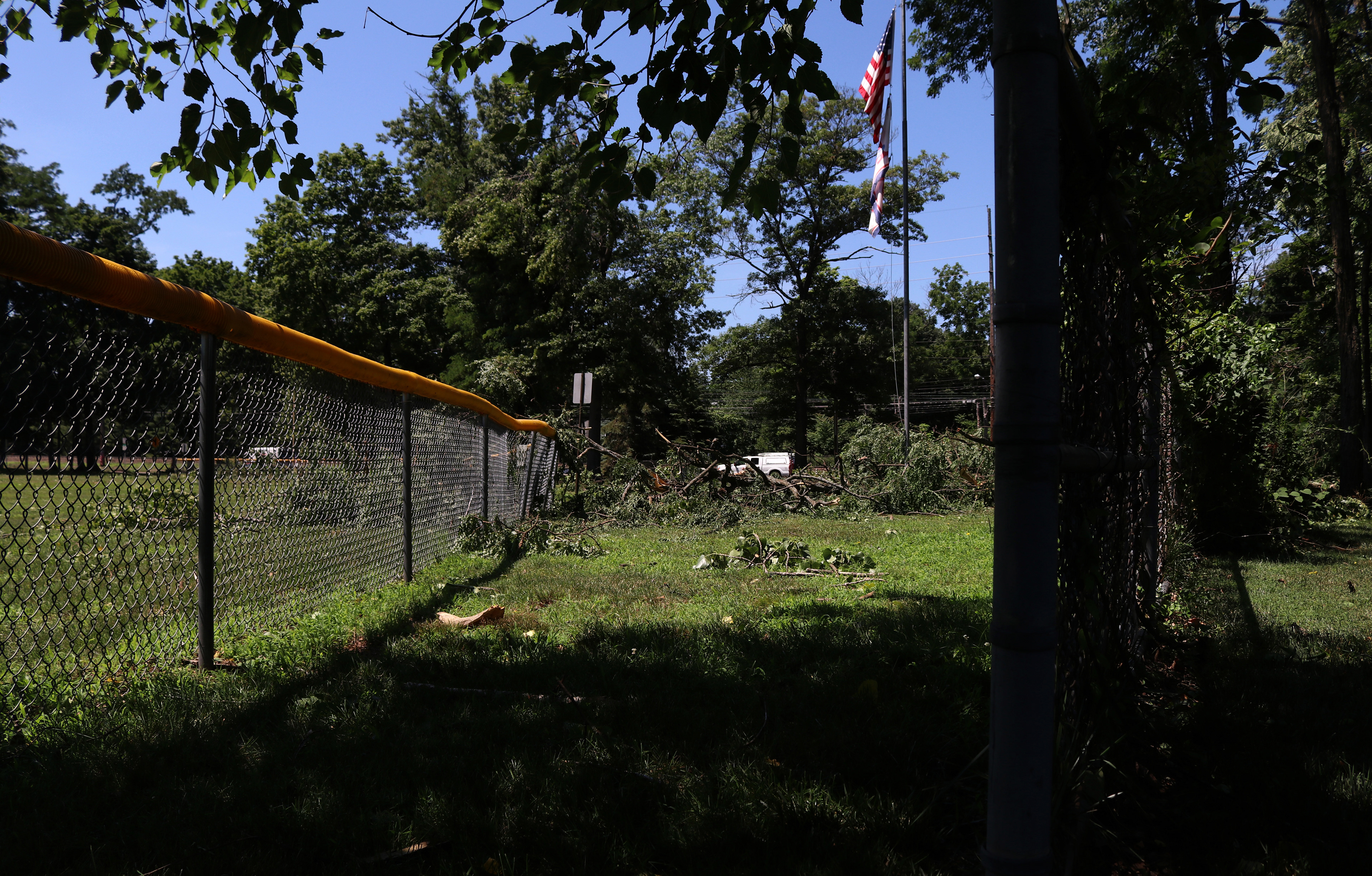 Fallen branches weigh down metal fences at the Veterans of Foreign Affairs #3401 and Veterans Park after a powerful storm in Morris Plains, New Jersey. Photo by Sunah Choudhry