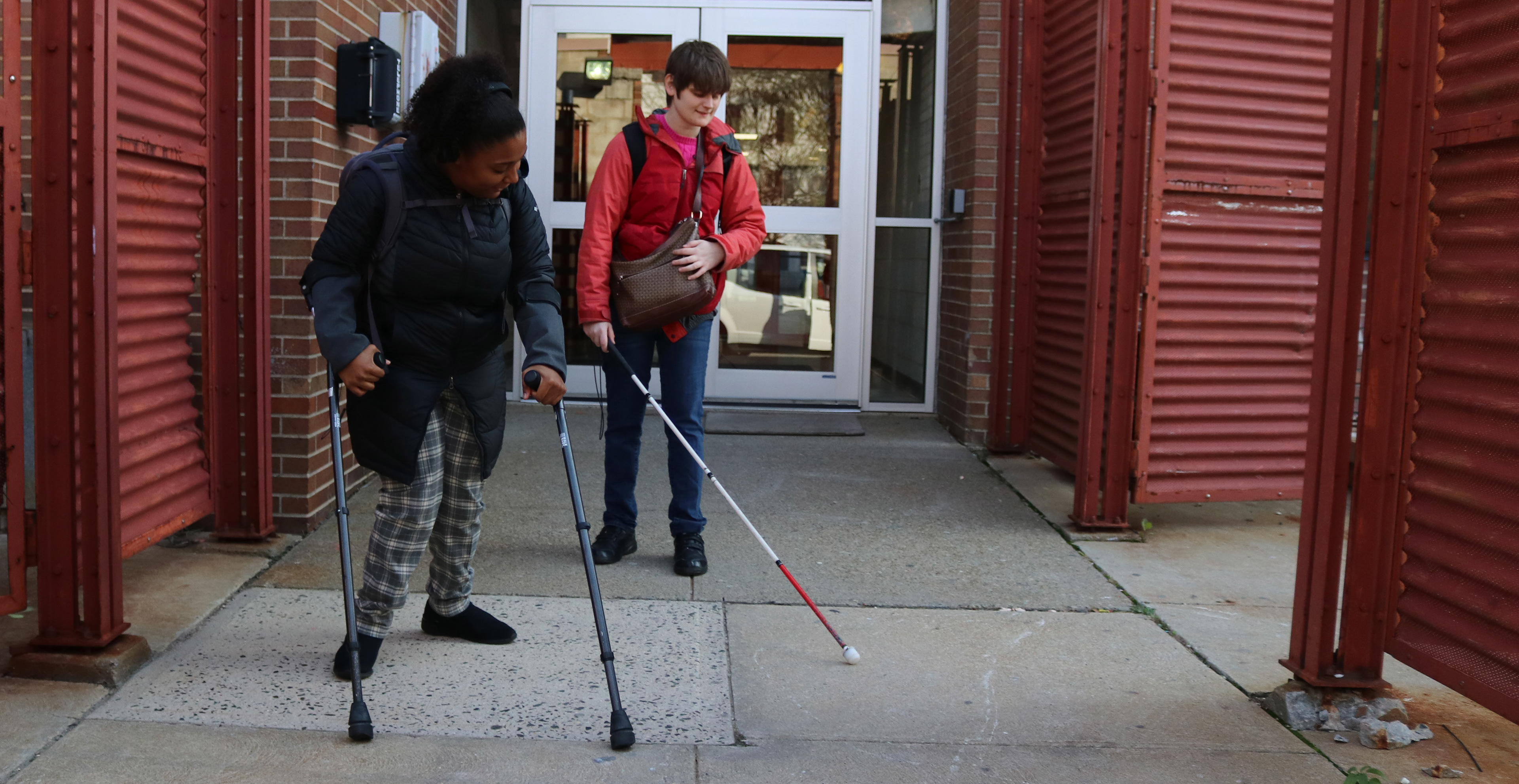 MONTCLAIR, NJ 11/11/2019 OUT OF SERVICE: Trinity Corney assists Amy Albin to the diability van while on her way to class in front of Calcia Hall out of choice. Albin is blind so she uses a stick to sense where she is walking.   -Photo by Sunah E. Choudhry