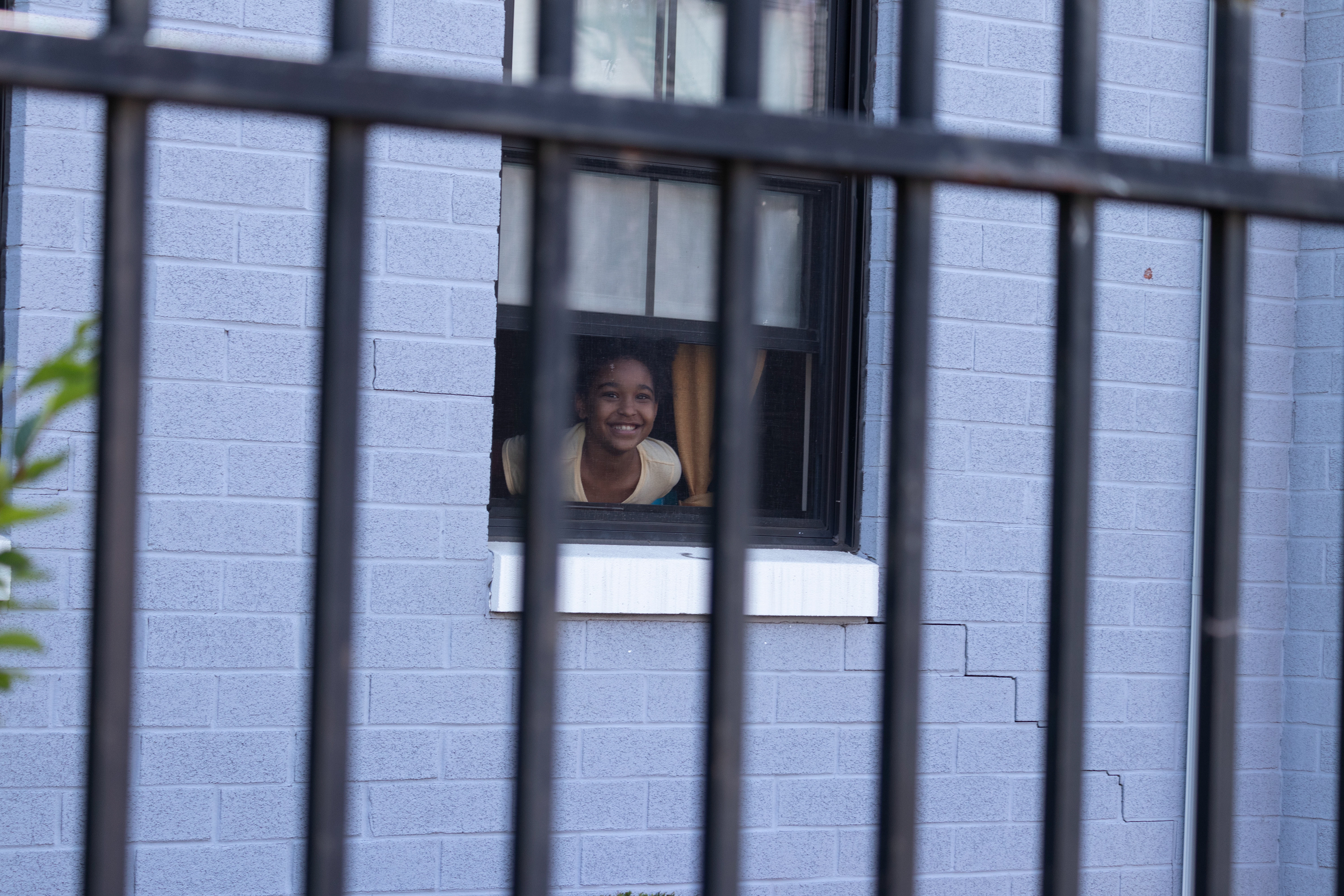 A girl cheers on Black Lives Matter protests from her lower-level apartment in Jersey City. (Photo/Sunah Choudhry)