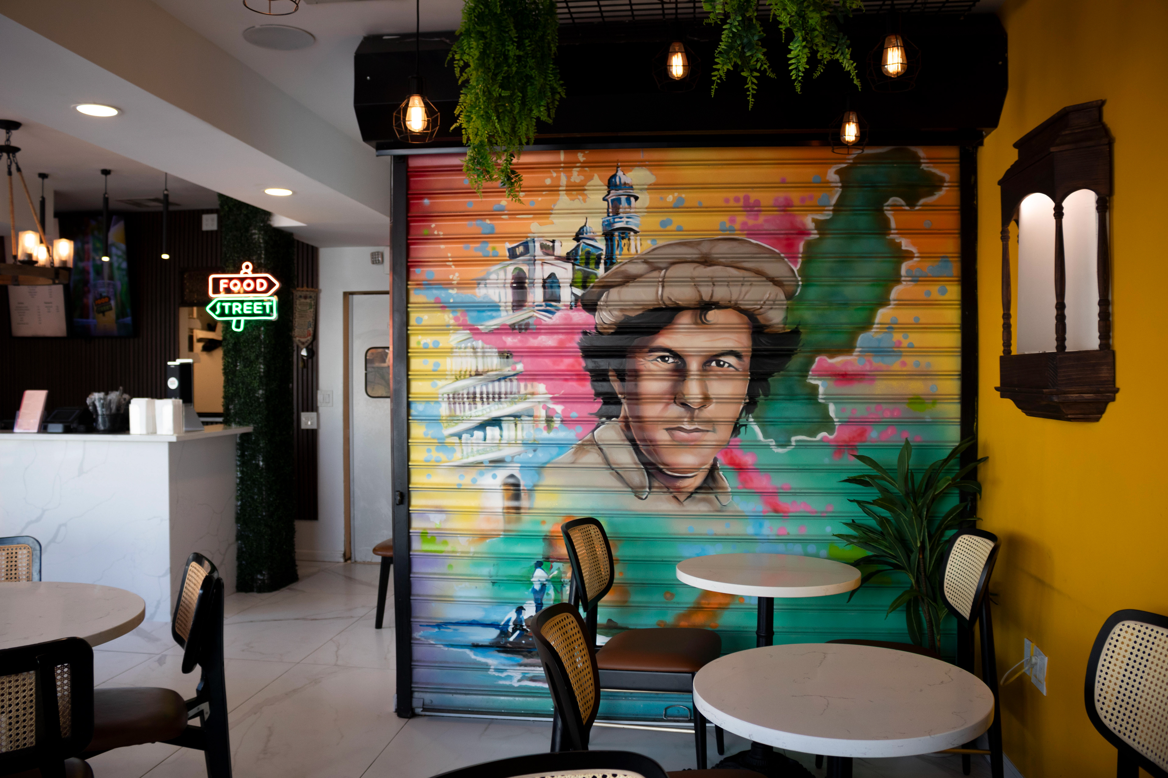 Food Street displays its national pride on metal rolling shutters for Pakistan's former Prime Minister Imran Khan. Rolling shutters are painted in Karachi and Lahore to attract customers in an overcrowded market and is an extension of truck art culture. Photo by Sunah Choudhry.