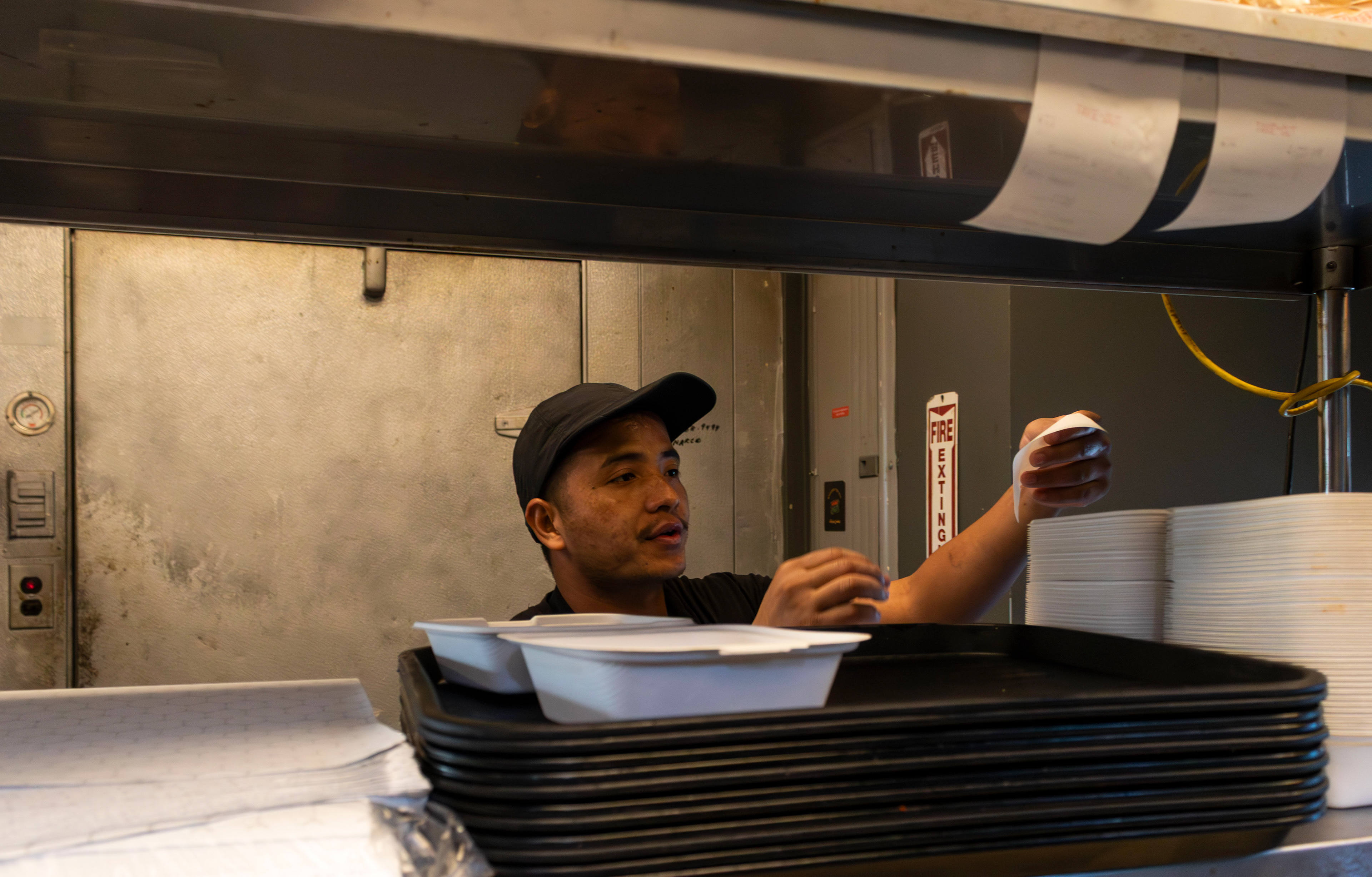 A cook grabbing the next ticket. Photo by Sunah Choudhry.
