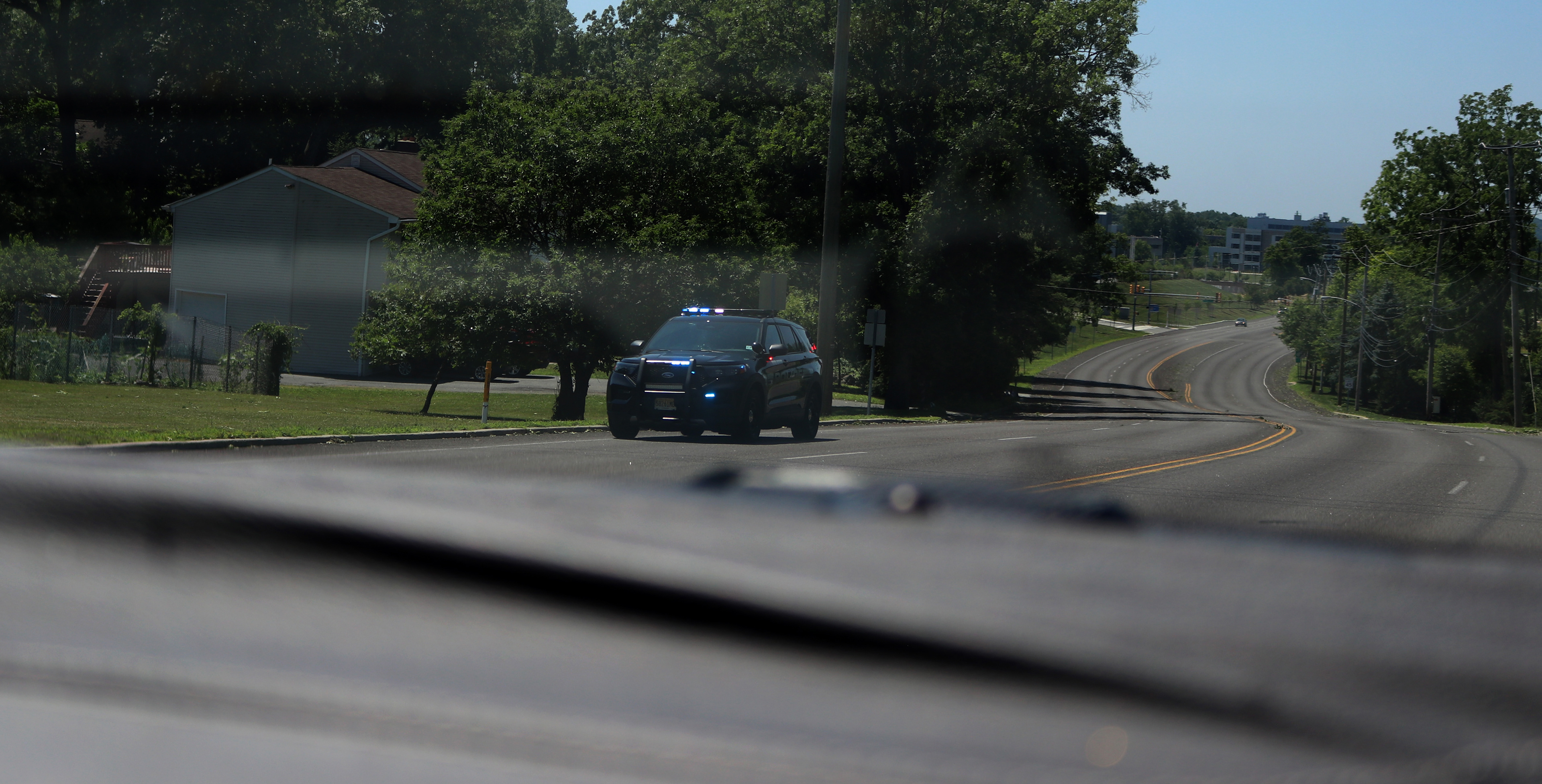 A Morris Plains Police vehicle travels along Tabor Road with its emergency lights on after the July 3 storm. Photo by Sunah Choudhry.