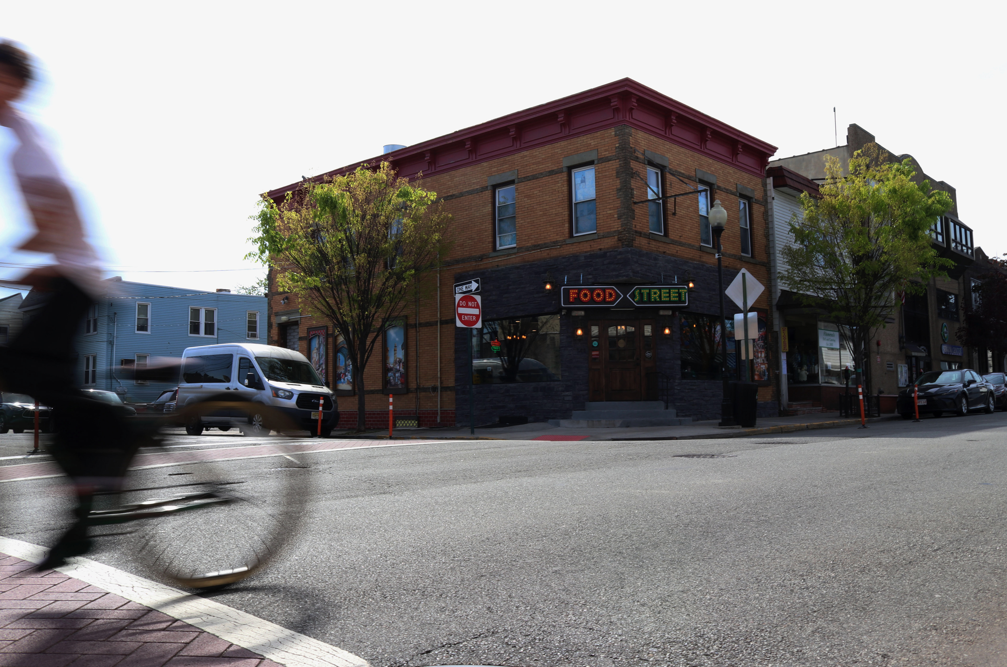 A teenager rides his bike past Food Street on Front Street in Secaucus, New Jersey. Photo by/Sunah Choudhry)
