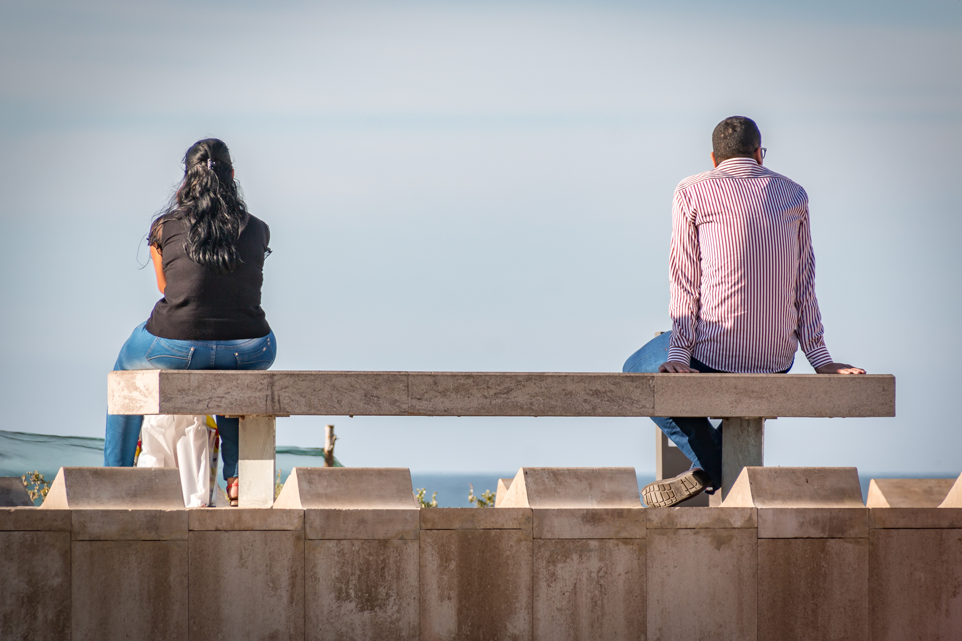 Un couple en bord de mer qui garde ses distances