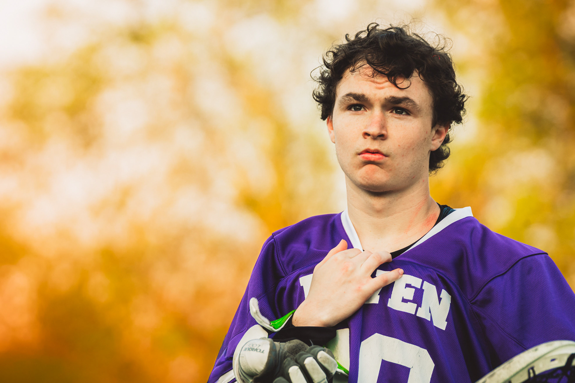 Senior goalkeeper Evan Tevlin stands for the national anthem as the setting sun casts a glow over the field before kickoff.
