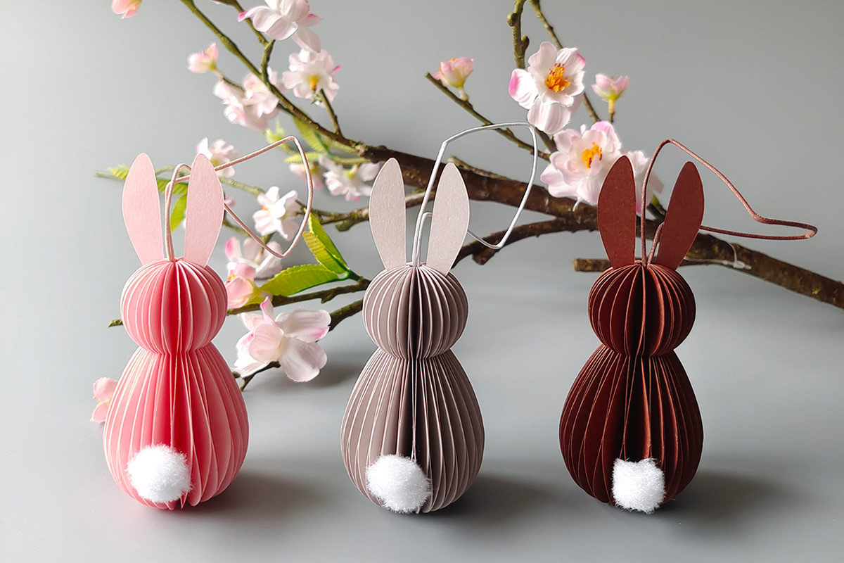 Gefaltete Osterhasen aus Papier in den Farben Rosa, Grau und Braun