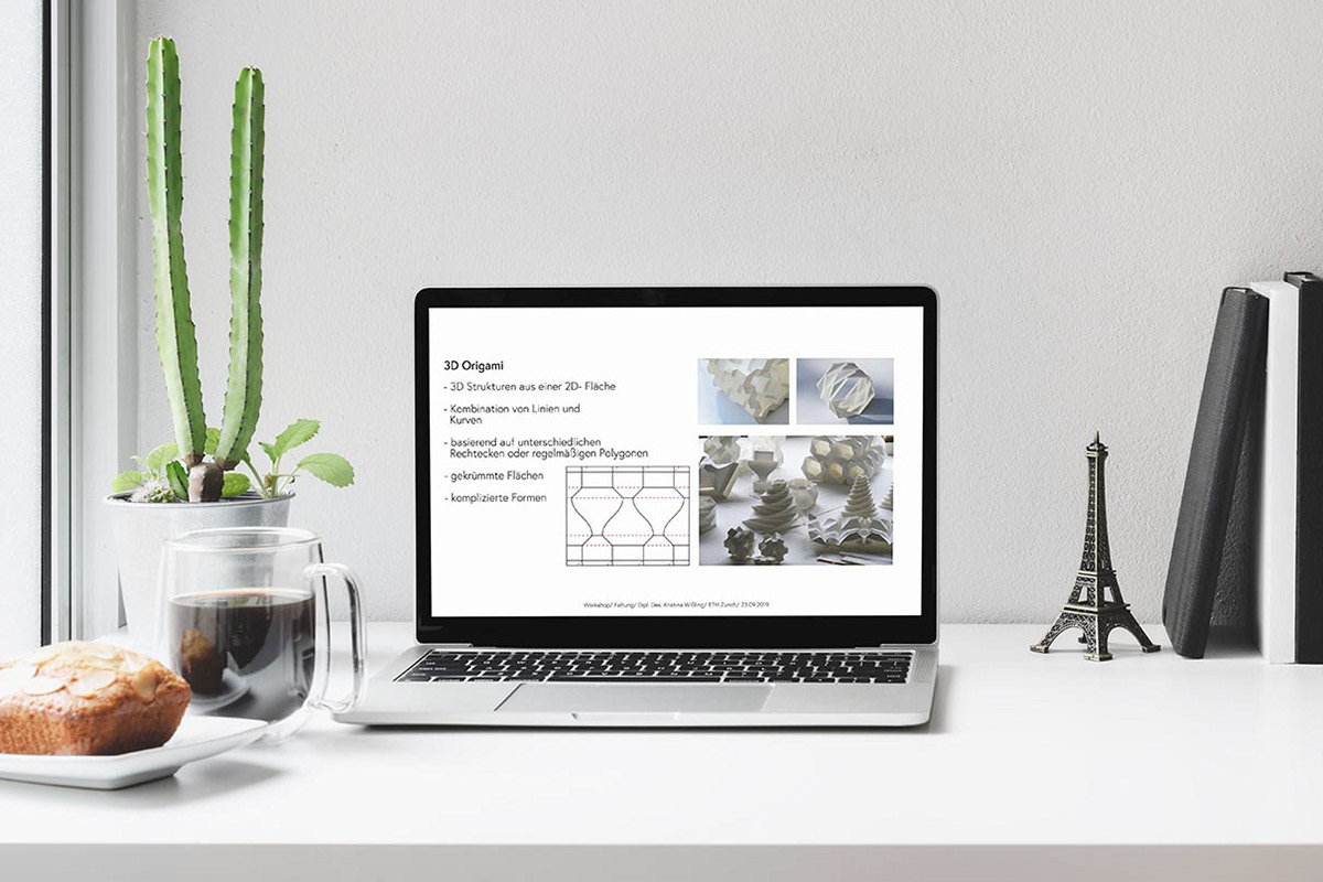 Laptop auf einem Schreibtisch mit einer Präsentation über Origami Falttechniken