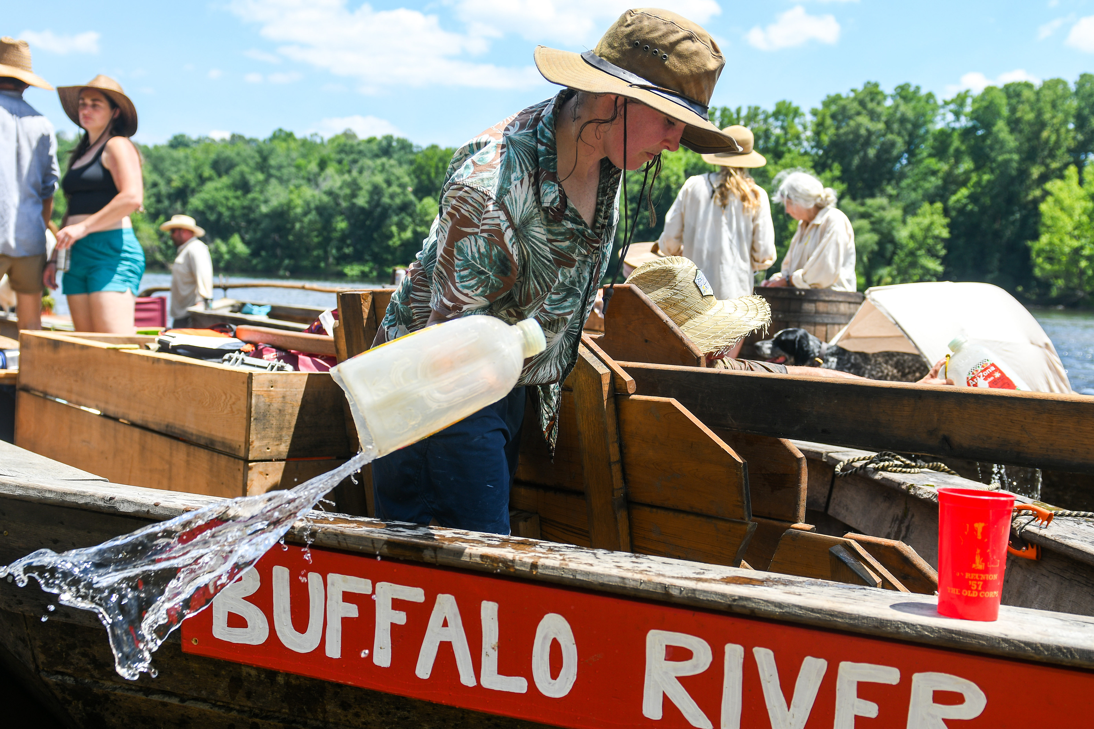Jackie Lambert, of the batteau Buffalo River, empties water out of the boat on Wednesday, June 19, 2024, during a break in the James River Batteau Festival's voyage to Scottsville. Emptying water is a routine maintenance task, as all batteaux are plugged with a natural rope and they will take on small amounts of water.