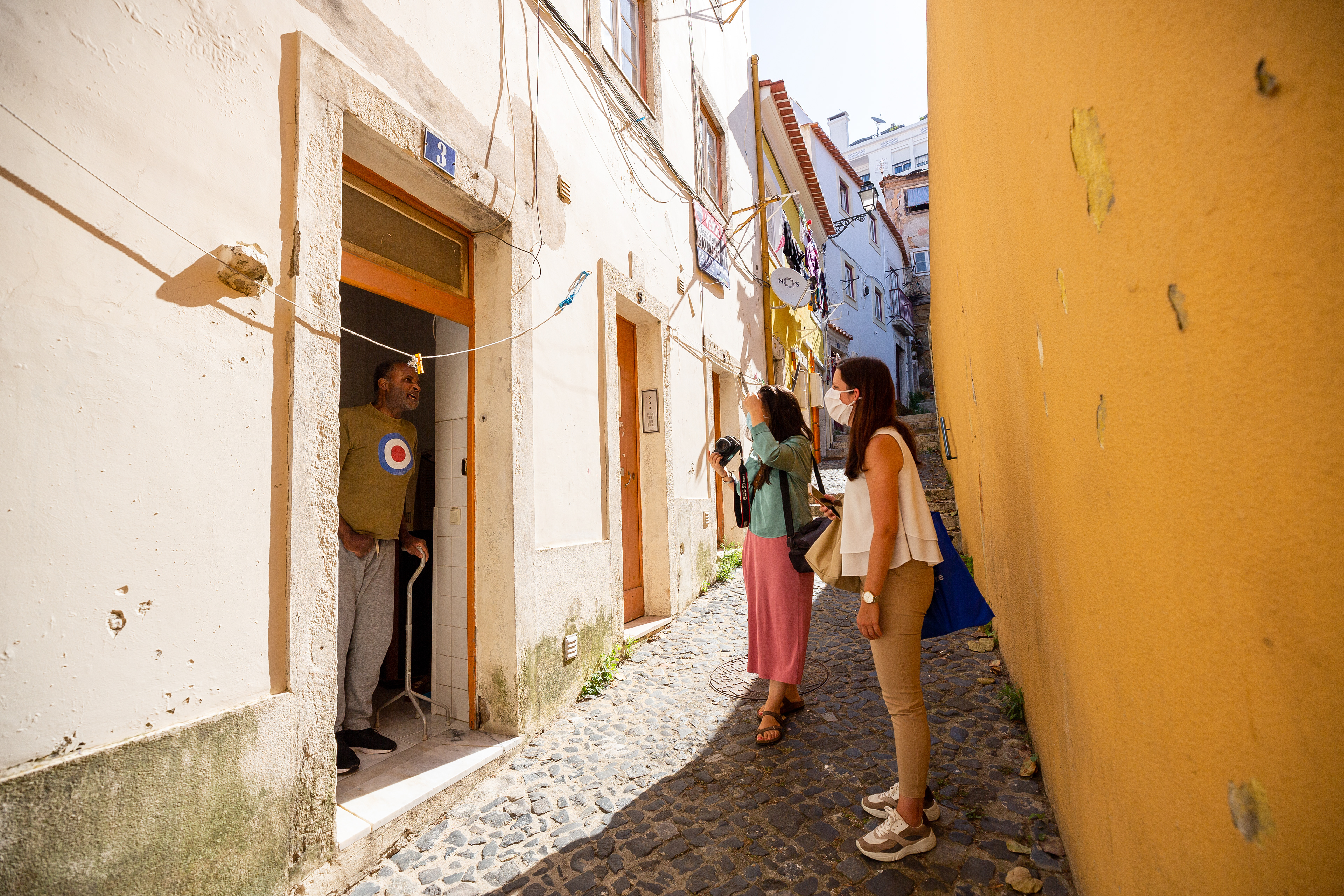 Volunteer photographer Ana Luísa Murjal is accompanied by the social worker Ana Sousa in a visit to Miguel Paulo, who lives in Mouraria, Lisbon