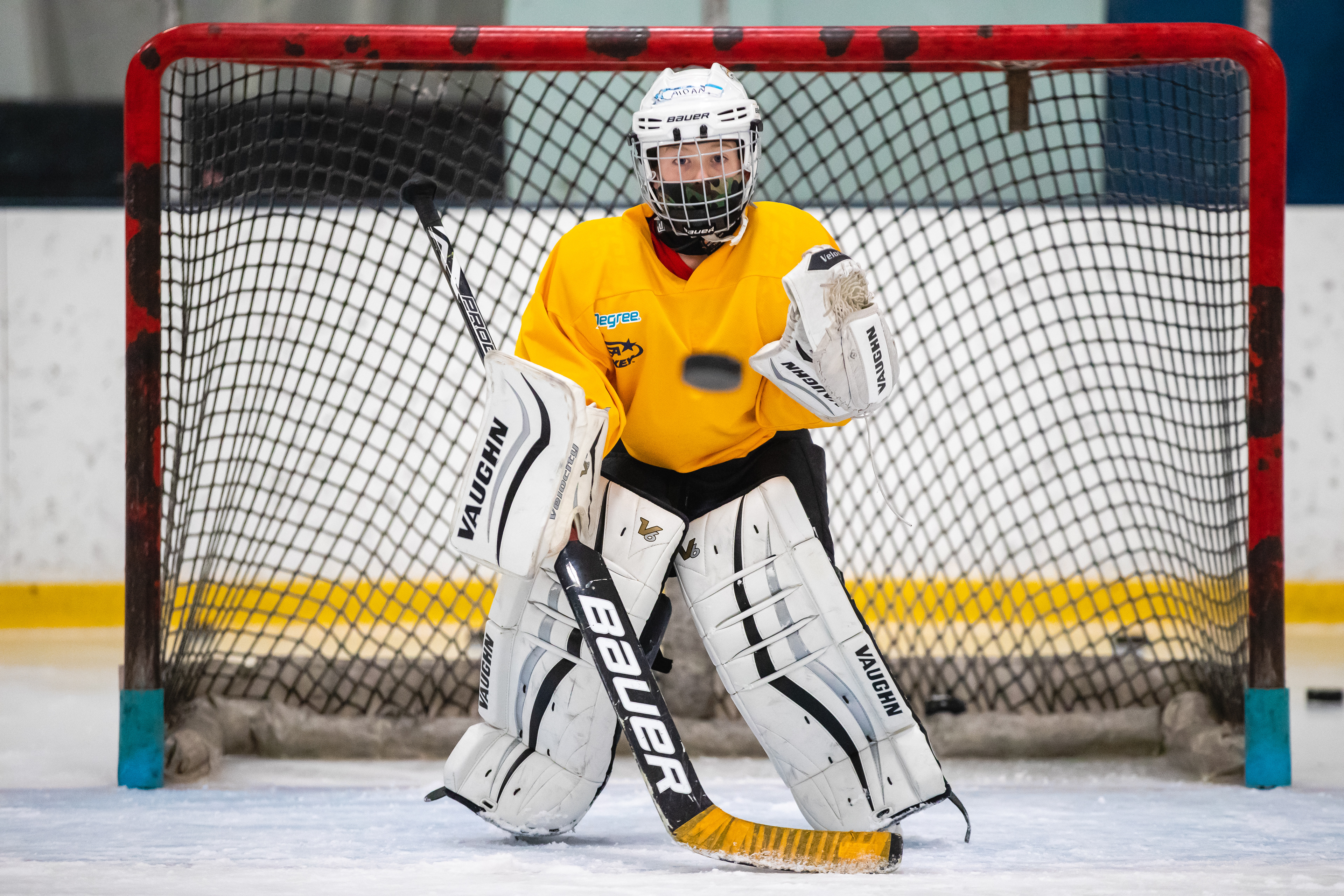 A young goaltender tracks the puck.