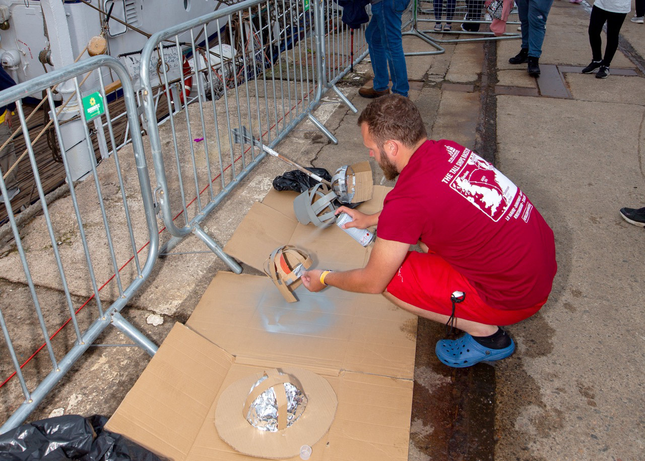 A crew member readies Viking helmets ahead of the Tall Ships parade