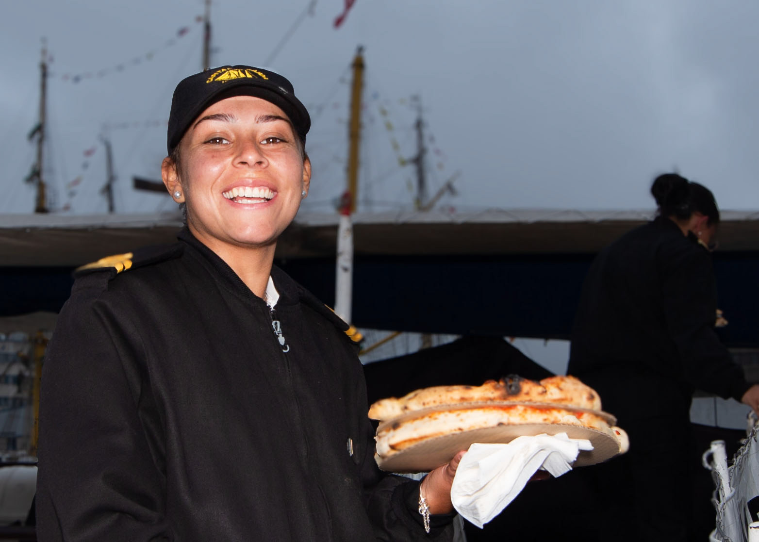 A smiling crew member boards her ship, supper in hand, a small comfort before tommorows cast off 