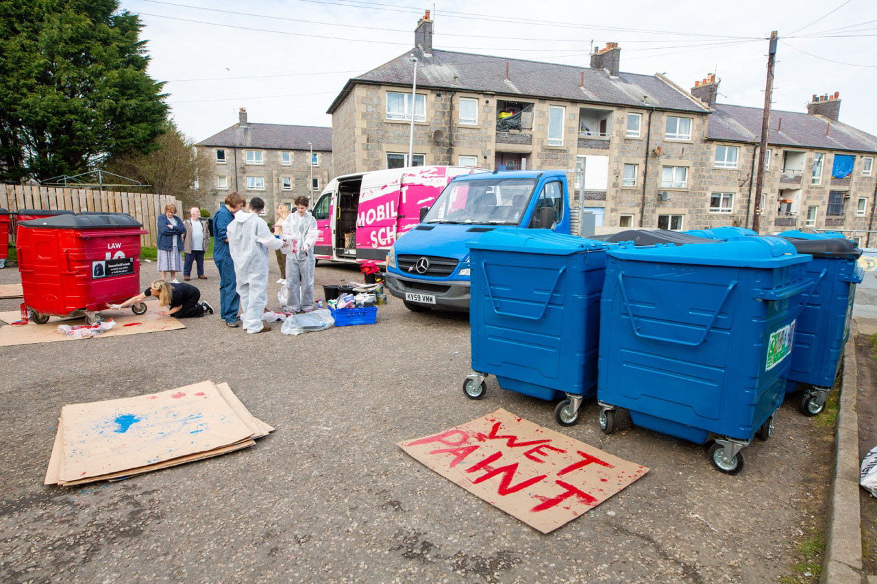 Final touches to the bin painting — the last careful marks bring colour, care, and character to a once-overlooked surface, turning the everyday into something shared and celebratory