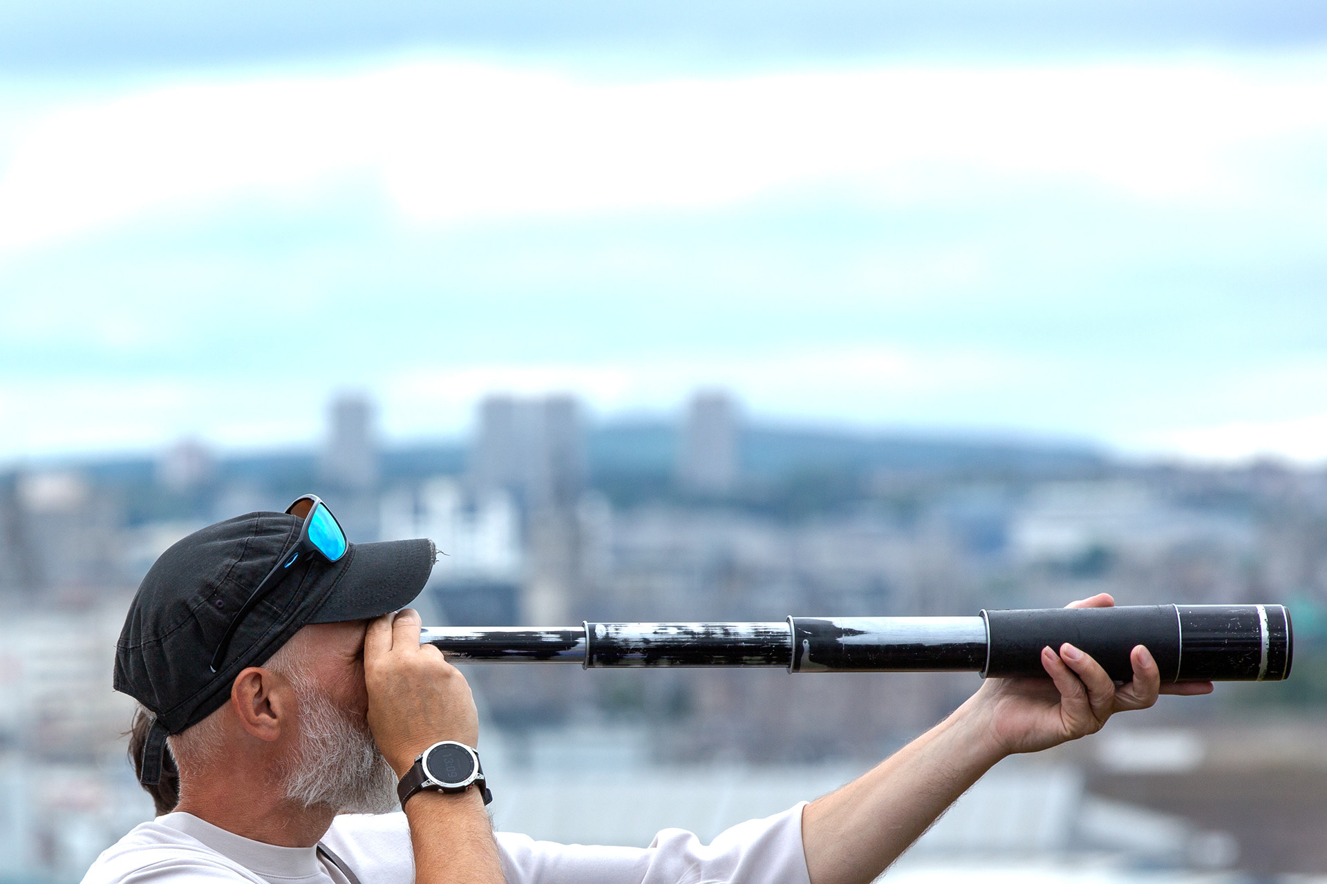 Visitor using a Vintage Telescope as the Tall ships sail off to their next port. 