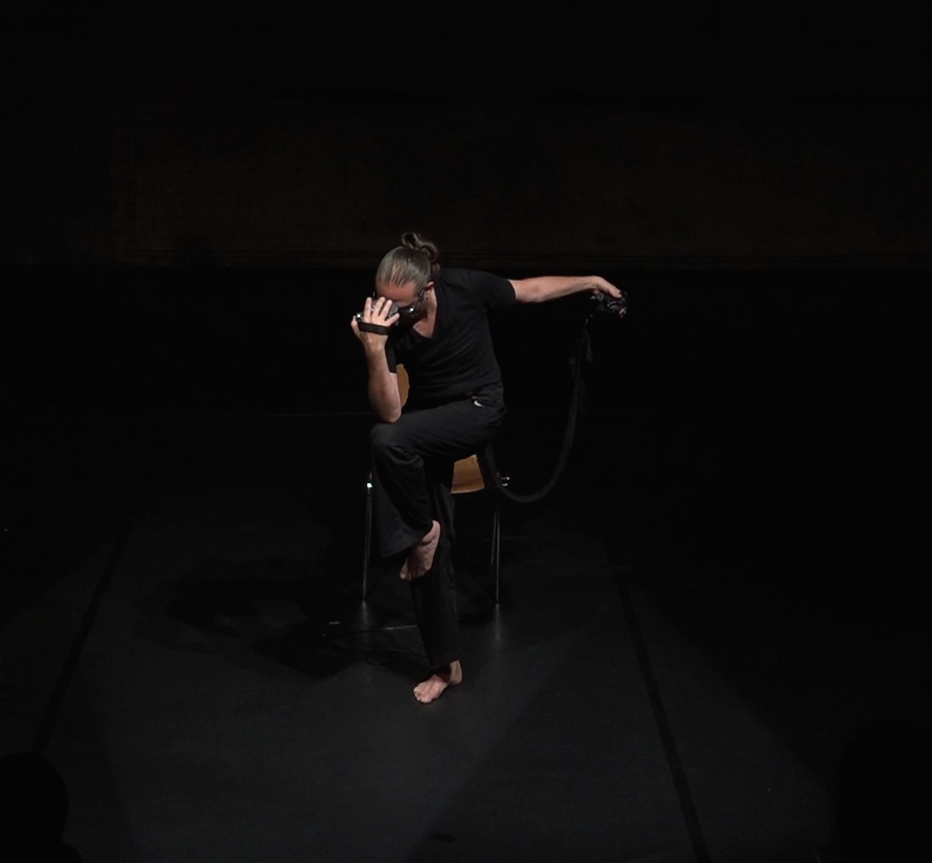 Still image of A.N. performing 'Untitled' for voice and gesture-controlled live electronics (strophonion), DOCK 11, Berlin 2016