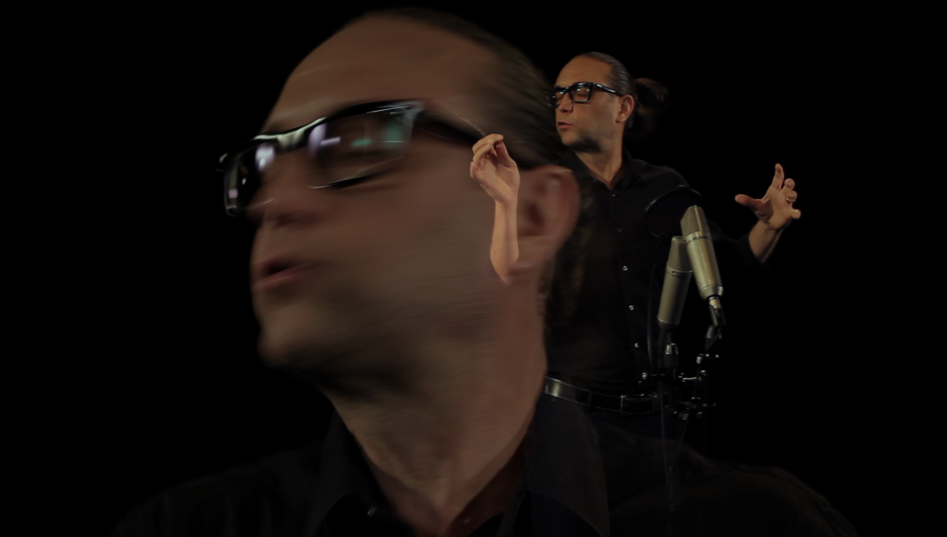 Still image of A.N. performing 'Panache' for voice solo, from a video recording by Oscar Loeser