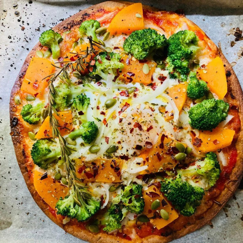 Pumpkin, broccoli, chili and egg pizza with its roasted pumpkin seeds