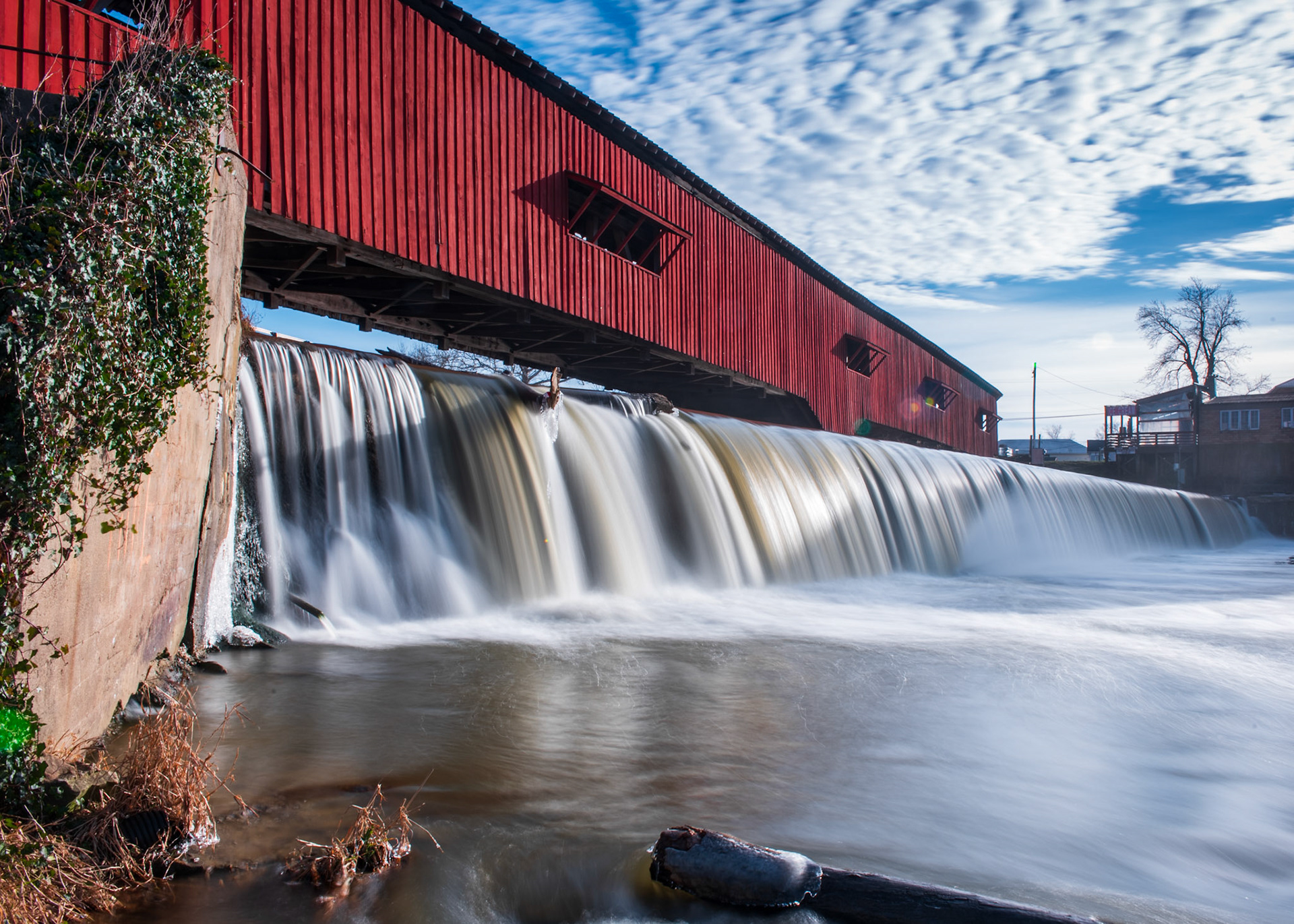 Smooth water falls under a covered bridge
