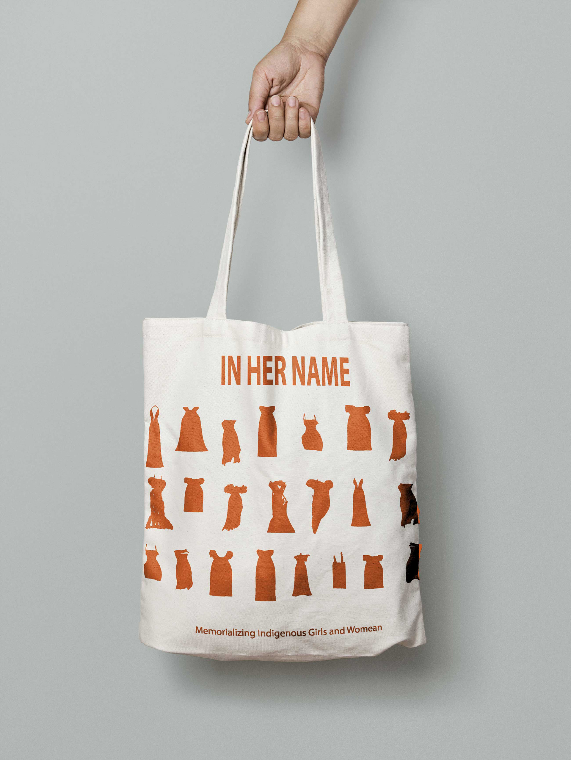 hand holding bag with screen printed red dresses