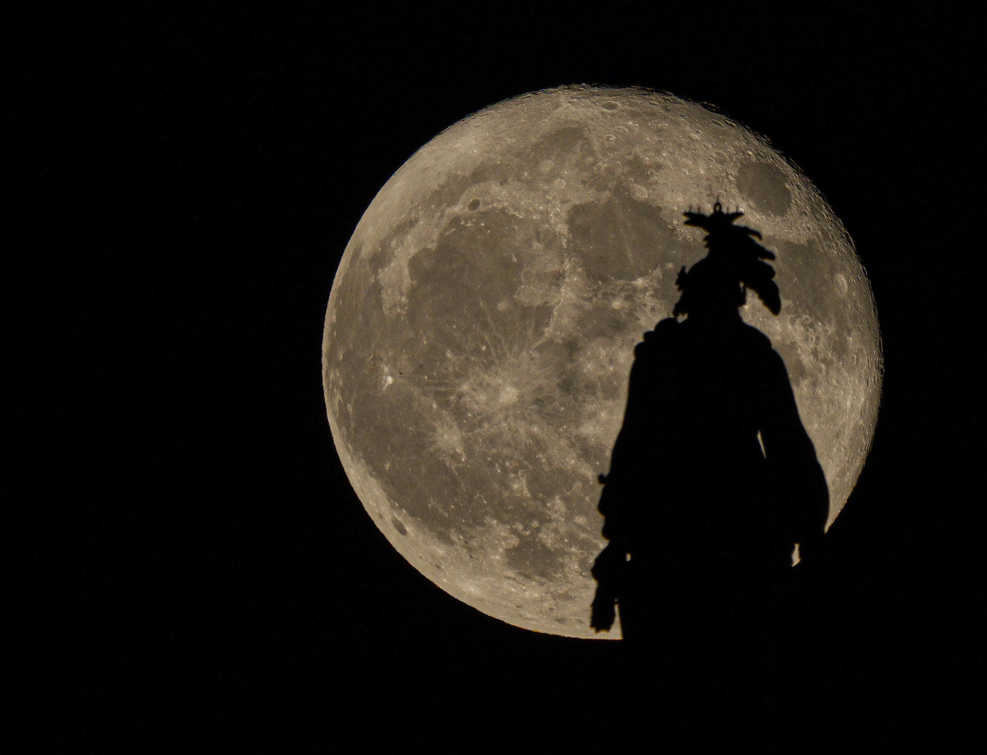 Waning full moon rises behind the Freedom Statue atop the U.S. Capitol Building. (Washington, D.C.)