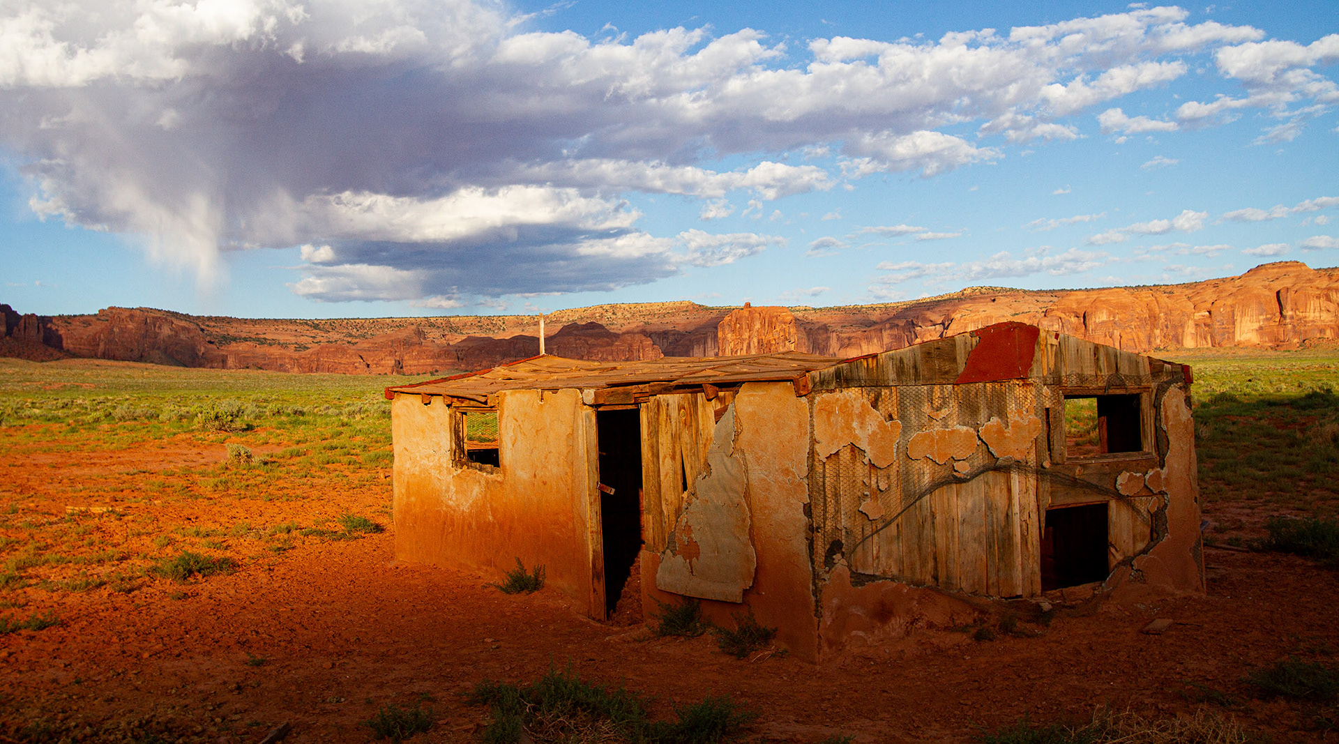 Sunlight rises over a ridge to light an abandoned home. (Monument Valley, AZ)