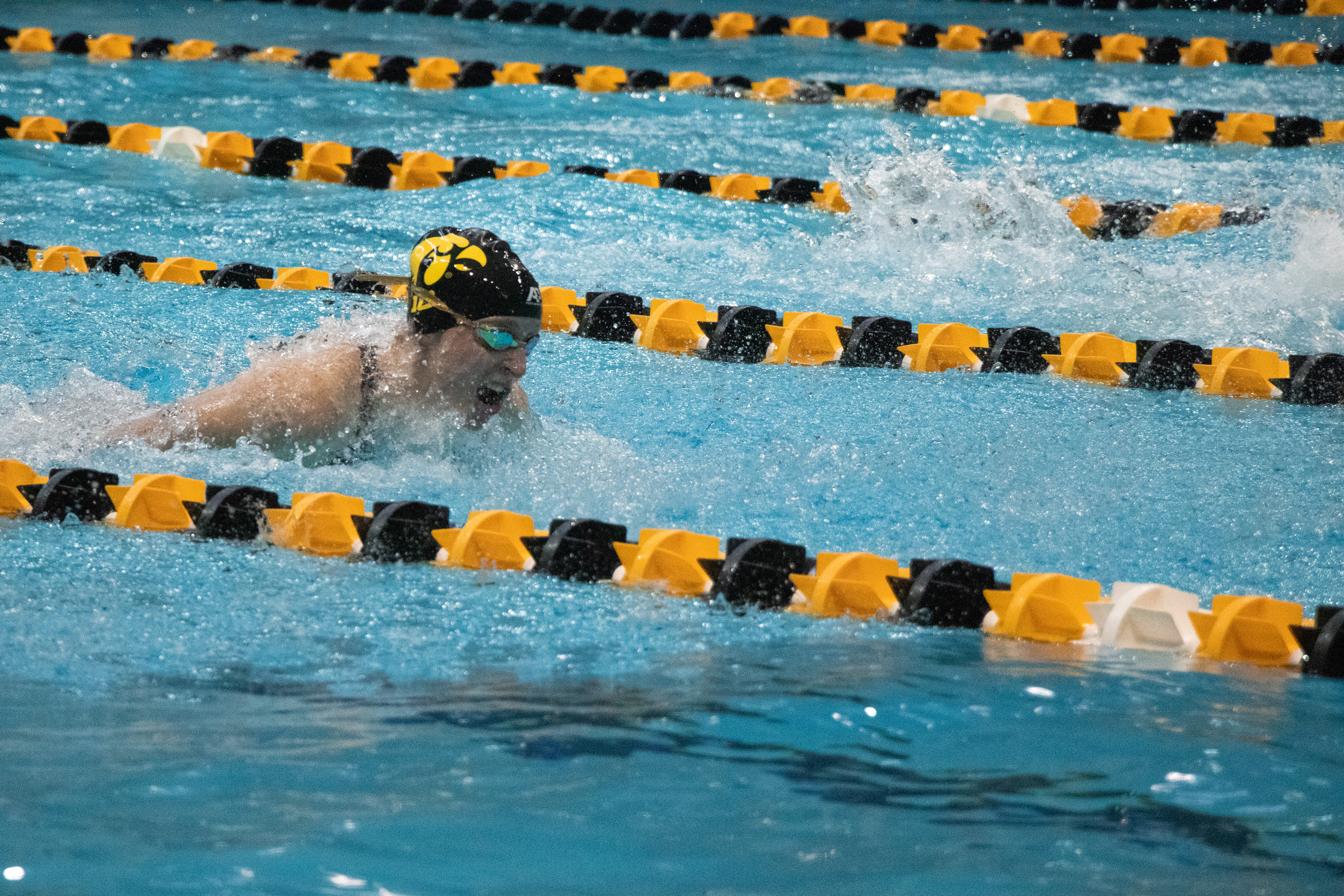University of Iowa’s Rachel Dildine (left) flies through the pool during the 100- meter Butterfly preliminary where she swims her personal best with a time of 55.20 and places fourth. In Iowa City, IA at the Campus Recreation and Wellness Center on Nov. 22 2024 during the Hawkeye Invitational Swim Meet. (SJMC/Sierra Christensen)