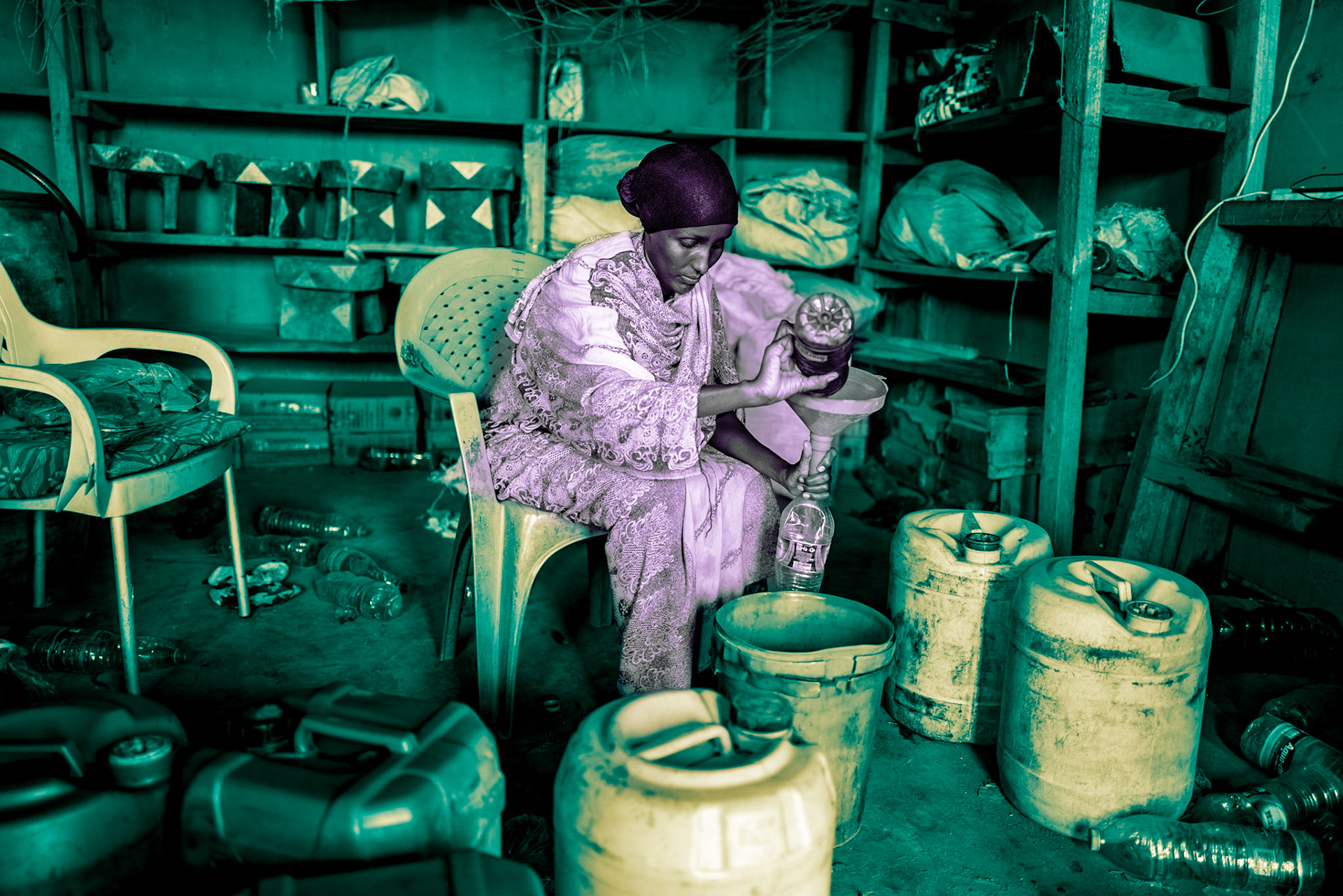 A Gabra woman is filling 1L water bottles with petroleum to sell to BodaBoda (motorcycle) drivers in Dukana. BodaBodas are the primary mode of transportation in the region and are used to transport people and goods. There are no gas stations in these villages.