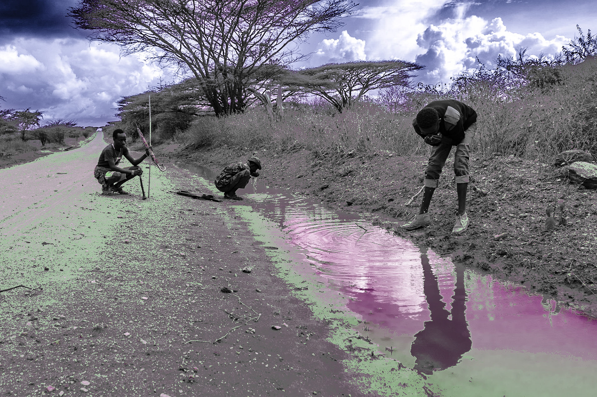 Three Samburu men are drinking rainwater from a roadside ditch after they escaped from being besieged by a group of local militias on the road to Baragoi.