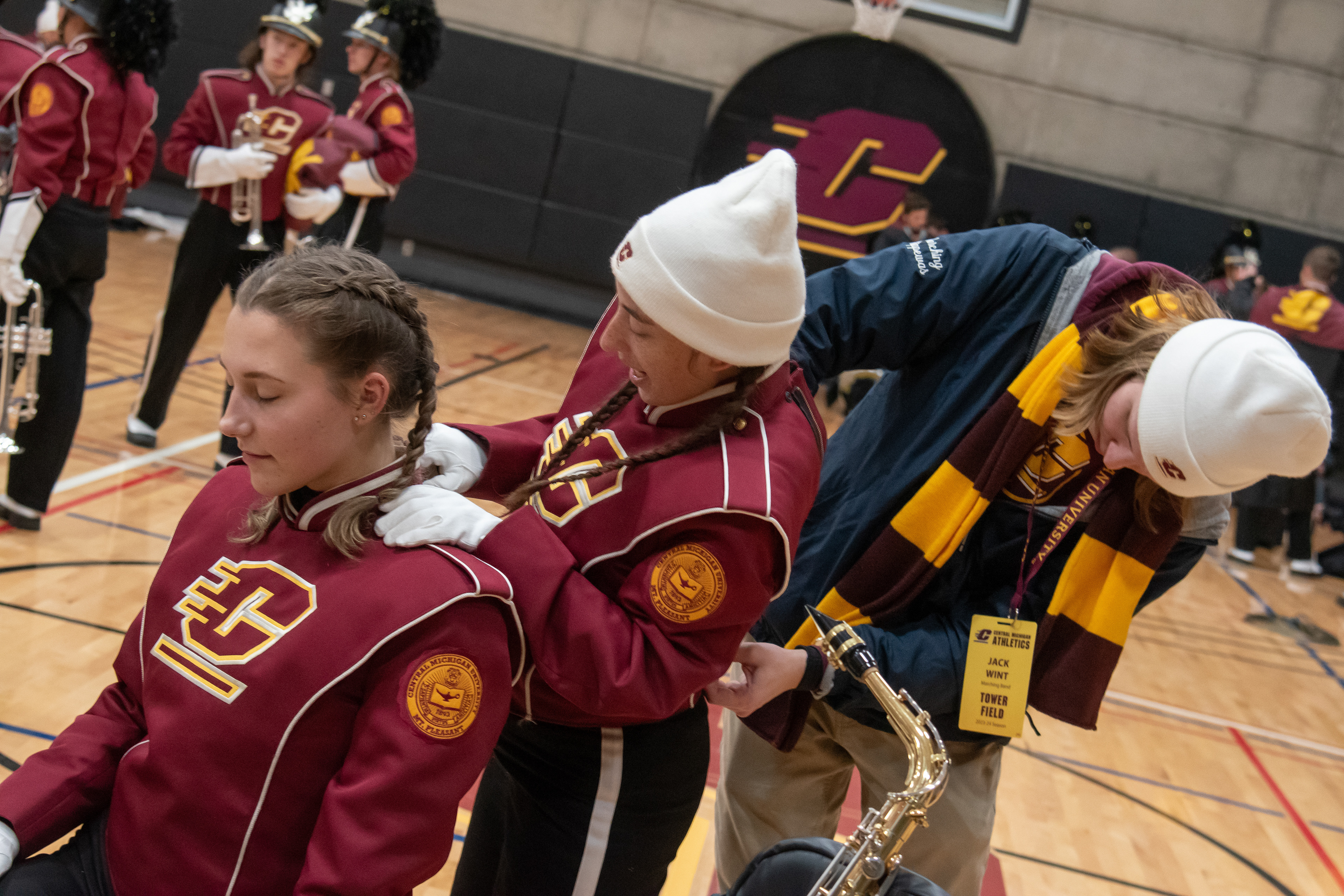 Adam Dodge, far right, helps Gaia zip up her uniform as Gaia helps Natalie Morehouse, far left, in the Student Activity Center, on the campus of Central Michigan University, Mount Pleasant, Michigan, Tuesday, October 31, 2023. Usually, Gaia’s partner helps with her uniform and pushing her chair, but Dodge agreed to help since her partner couldn’t make it. Dodge is a senior at CMU and met Gaia when he played trumpet for the band.
