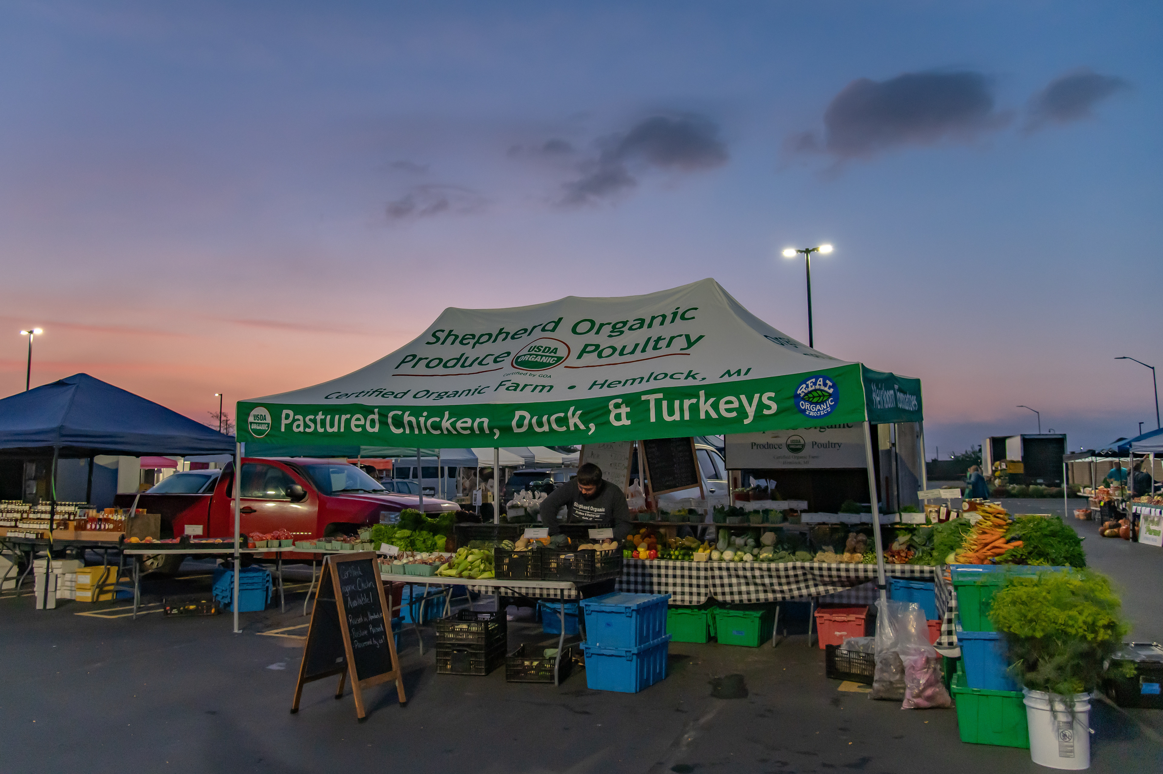 Tyler Shepherd adds more vegetables to the stand at the Midland Farmer’s Market, 825 East Main Street, Midland, Michigan, Saturday, September 30, 2023. Their customized tent Shepherd uses is new to their display.