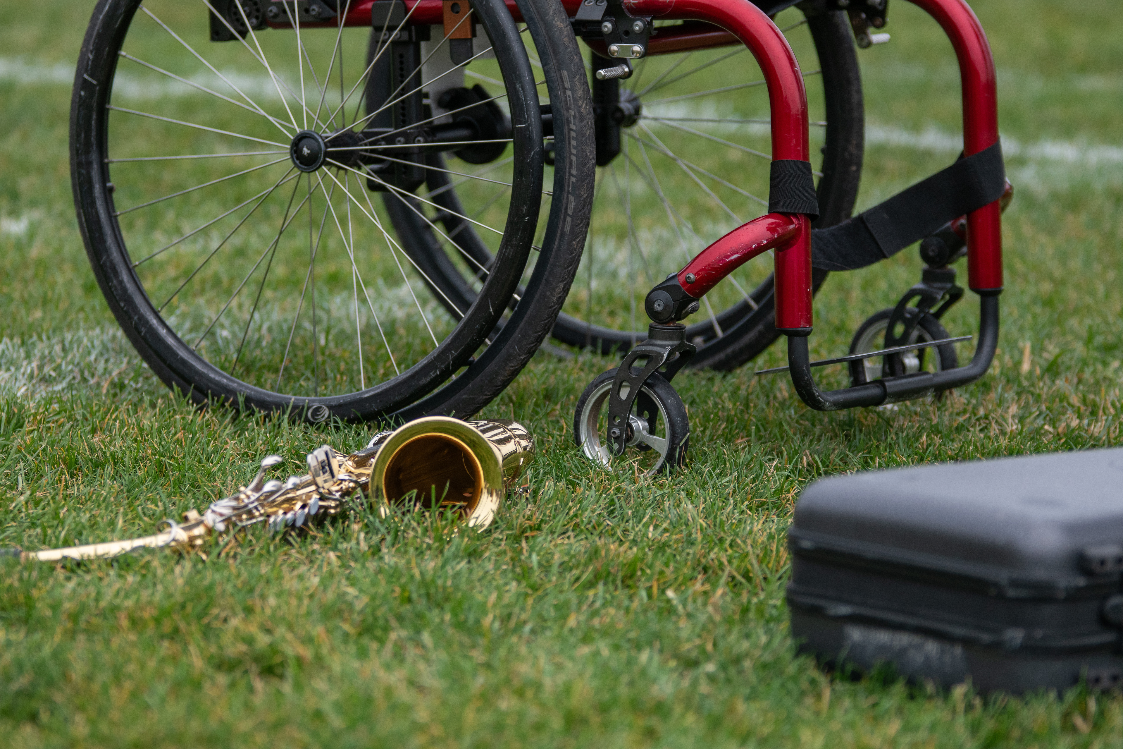 Gaia’s alto saxophone and wheelchair sit on the grass during rehearsals at Jack Saunders Marching Band Field, on the campus of Central Michigan University, Mount Pleasant, Michigan, Thursday, October 26, 2023. When Gaia first joined the Chippewa Marching Band, she played the clarinet. “Alto is so much fun,” she said. “I never regret that decision.”