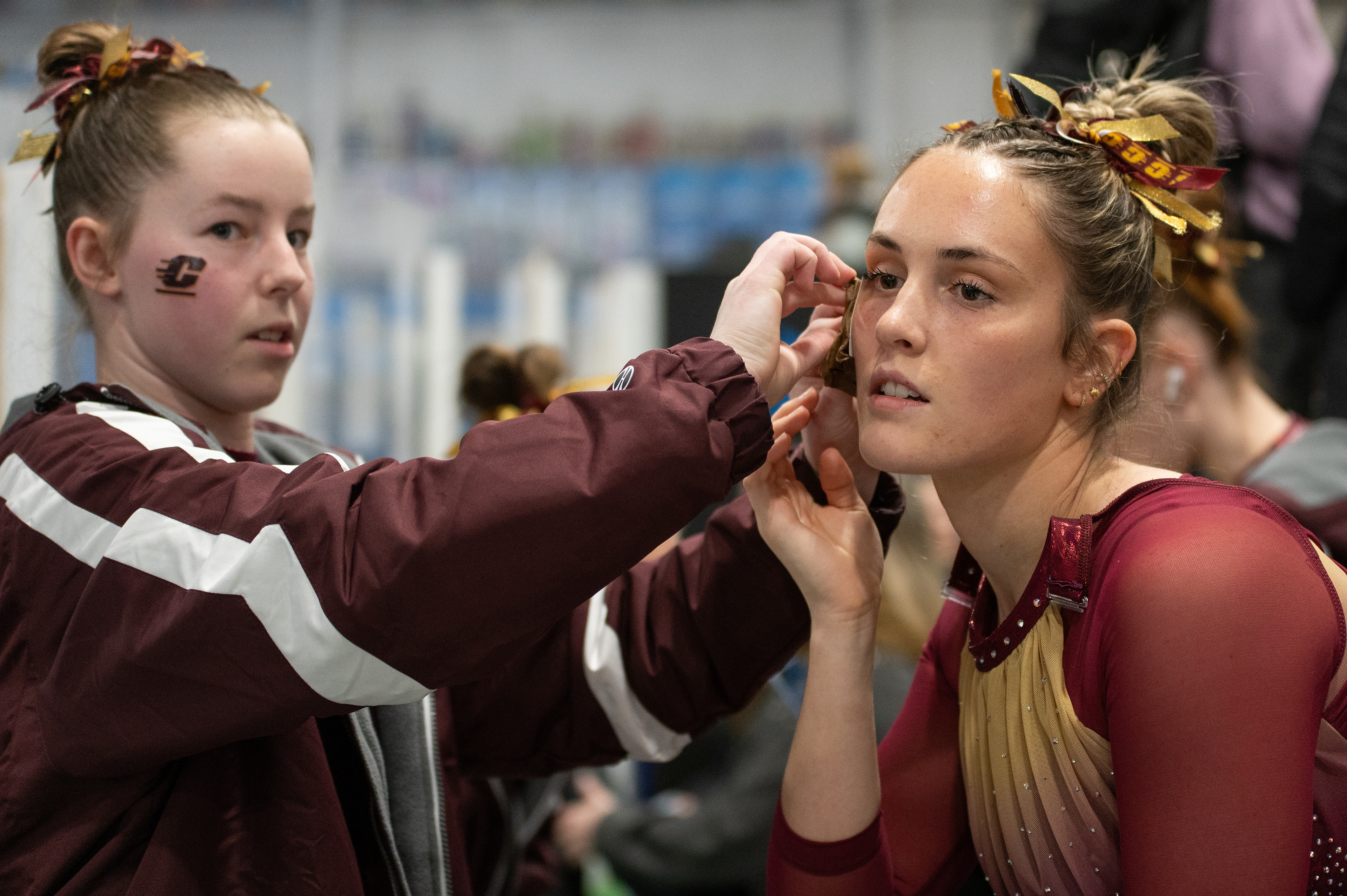Maddie Doody, left, applies a CMU temporary tattoo on Alexa Cusimano, right, before Grand Valley State University’s Health Heart Classic meet, Saturday, Feb. 24, at Kids Unlimited Activity Center, Jenison, Mich.